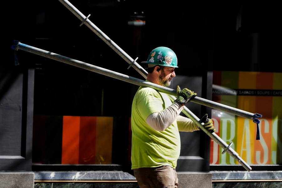 FILE - A construction worker carries scaffolding parts on March 14, 2024, in Boston. On Friday, August 2, 2024, the U.S. government issues its July jobs report. (AP Photo/Michael Dwyer, File)