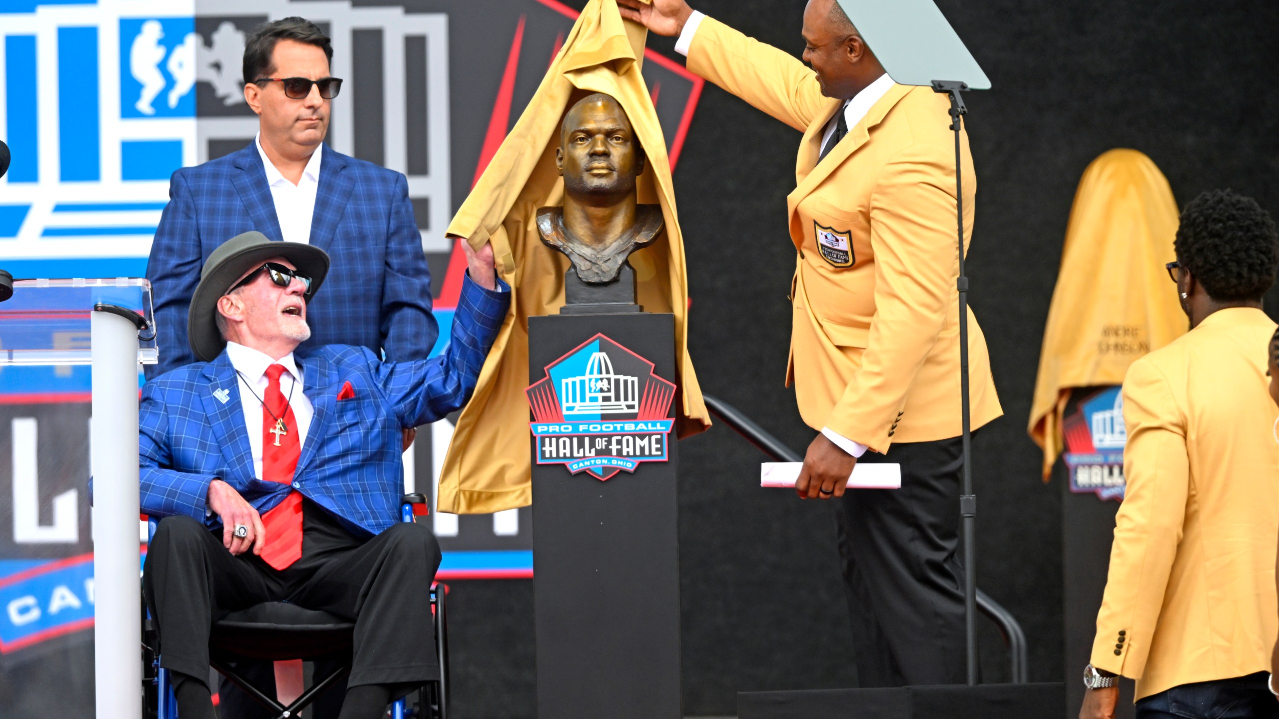 Former NFL player Dwight Freeney, second from right, and his presenter Jim Irsay, lower left, unveil his bust during an induction ceremony at the Pro Football Hall of Fame, in Canton, Ohio, Saturday, Aug. 3, 2024. (AP Photo/David Dermer)