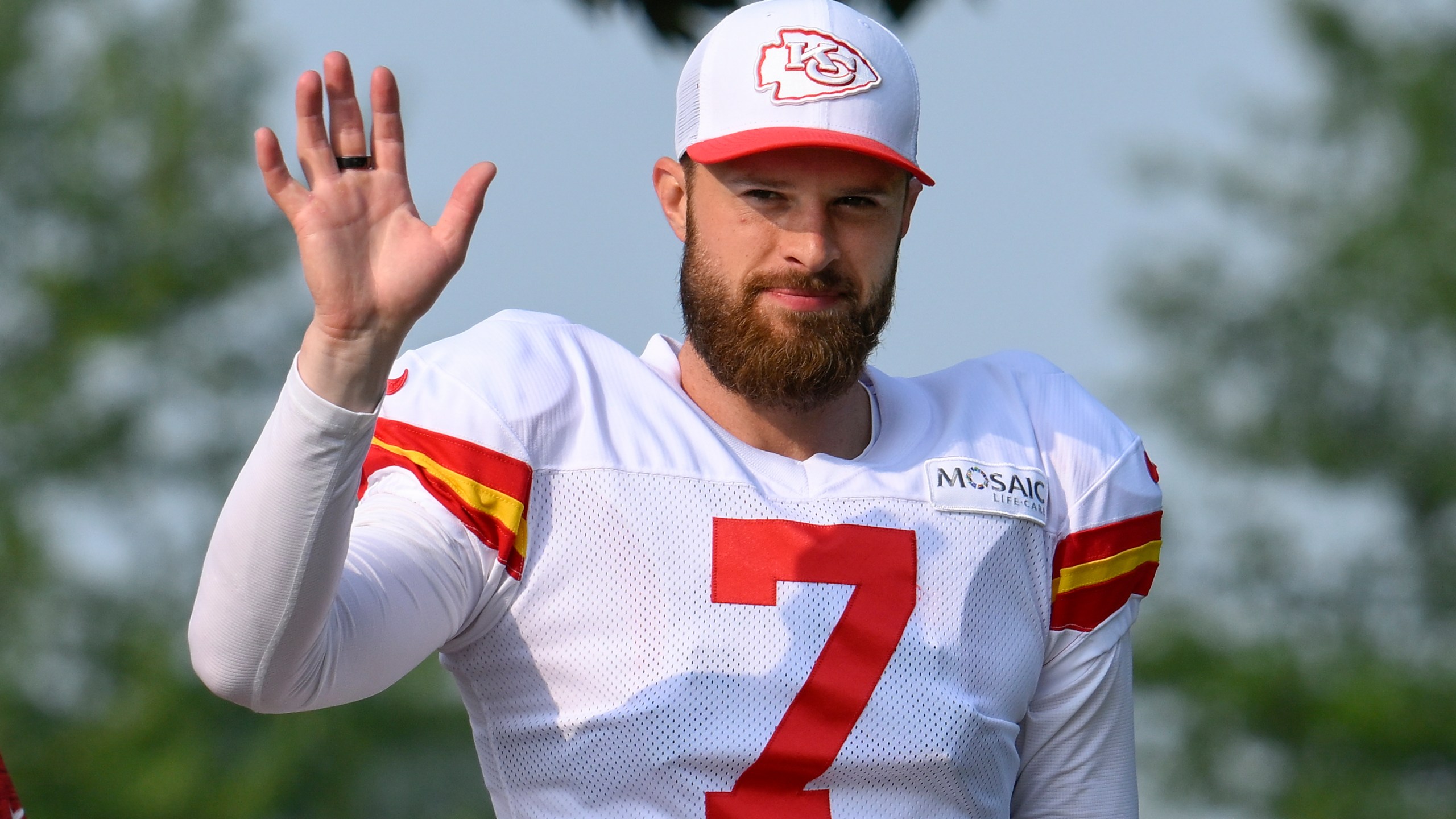 Kansas City Chiefs kicker Harrison Butker waves to the fans as he walks to the field at the start of an NFL football training camp Saturday, July 27, 2024, in St. Joseph, Mo. (AP Photo/Reed Hoffmann)