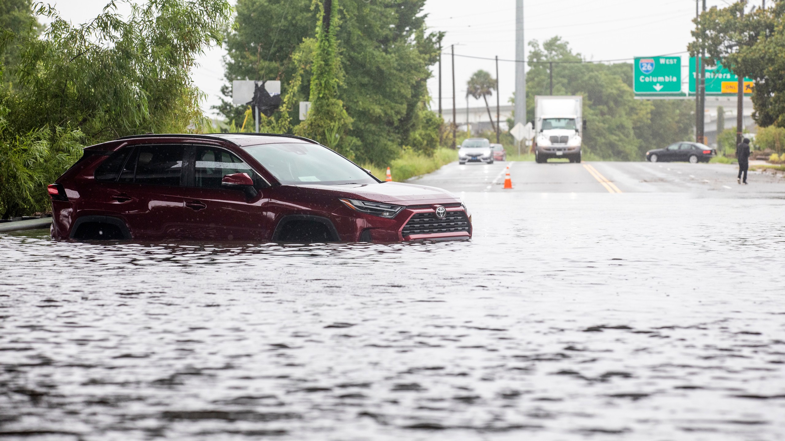 A car sits in flood waters near Spruill Ave in North Charleston, S.C., as Tropical Storm Debby approaches, Tuesday, Aug. 6, 2024. (AP Photo/Mic Smith)