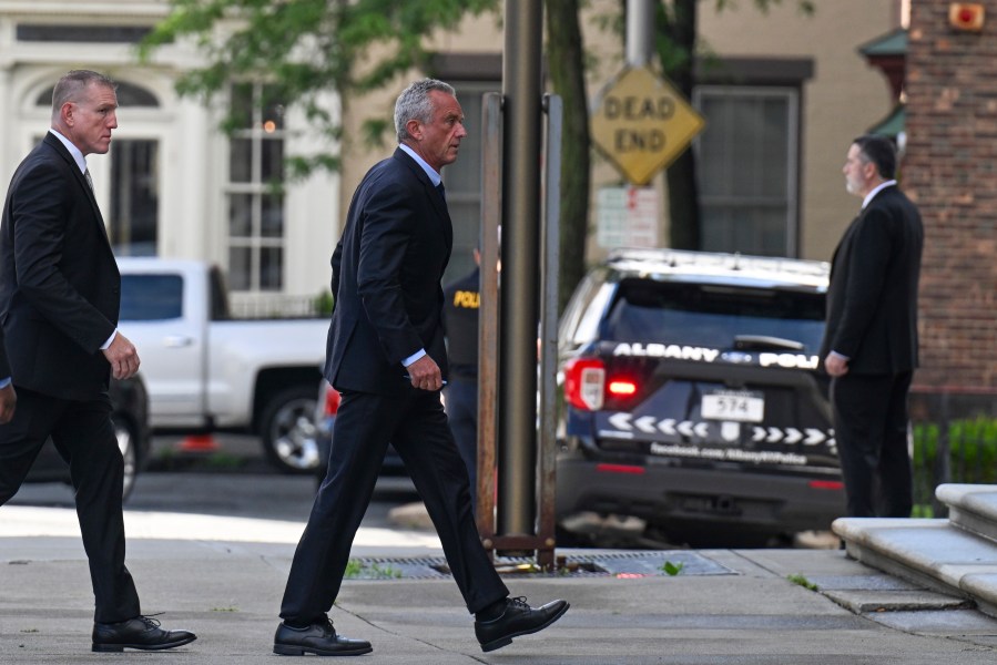 Independent presidential candidate Robert F. Kennedy Jr., right, arrives at the Albany County Courthouse to fight a lawsuit he falsely claimed to live in New York state, Wednesday, Aug. 7, 2024, in Albany, N.Y. (AP Photo/Hans Pennink)