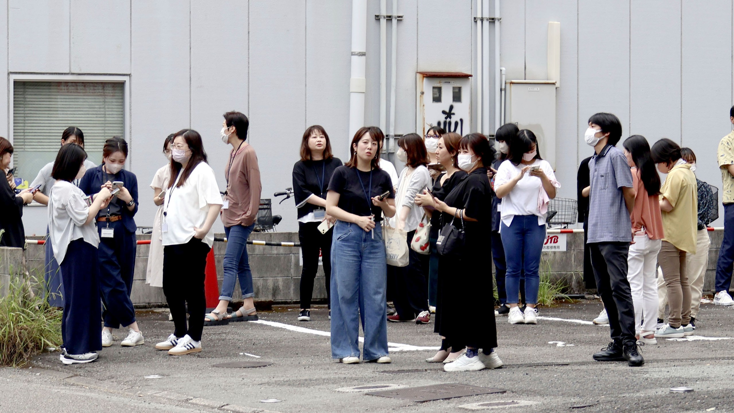 People take shelter outside building following an earthquake in Miyazaki, western Japan, Thursday, Aug. 8, 2024.(Kyodo News via AP)