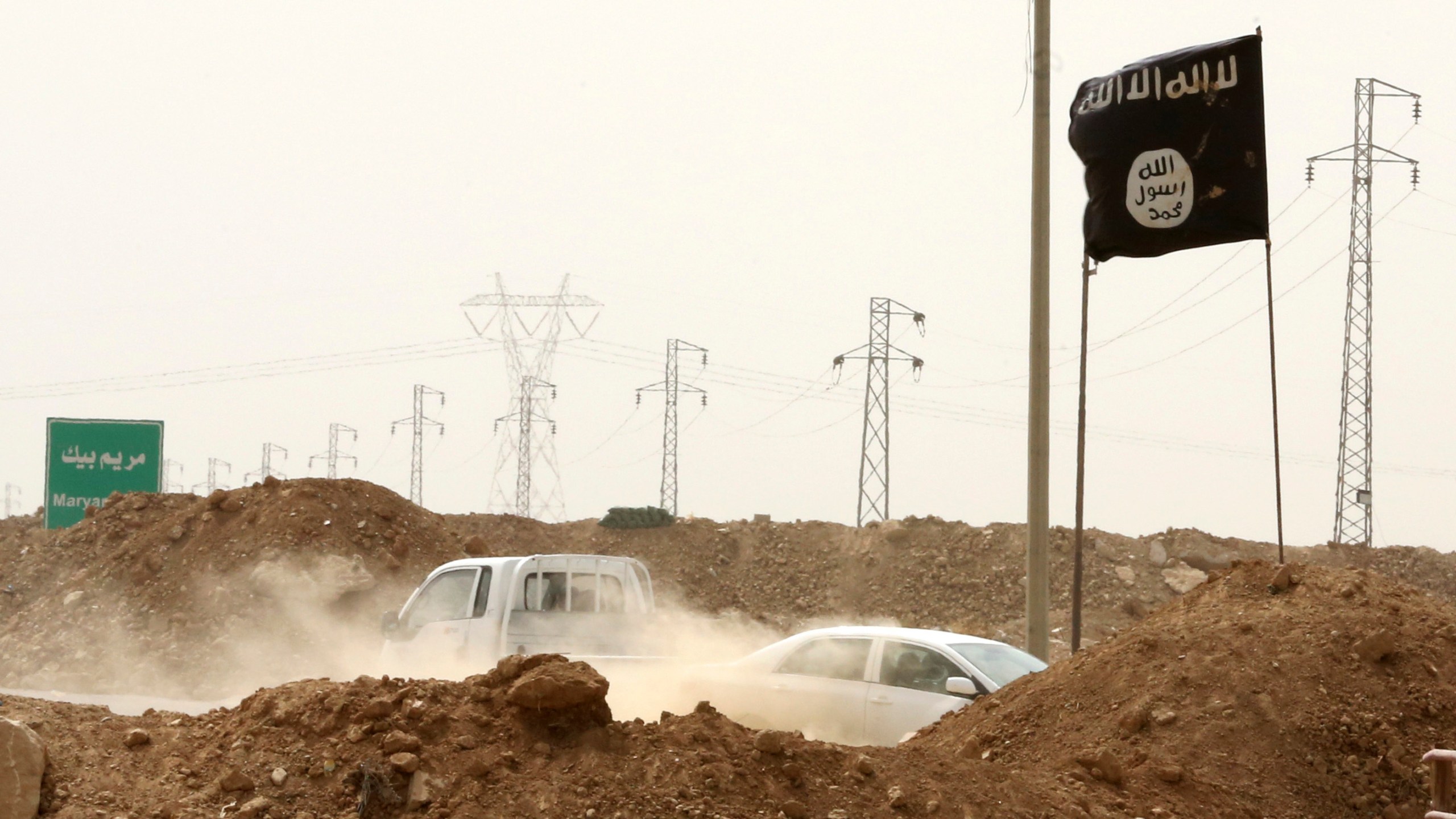 FILE - Islamic State militants pass a checkpoint bearing the group's trademark black flag in the village of Maryam Begg in Kirkuk, 180 miles north of Baghdad, Iraq, Sept. 29, 2014. (AP Photo/Hadi Mizban, File)