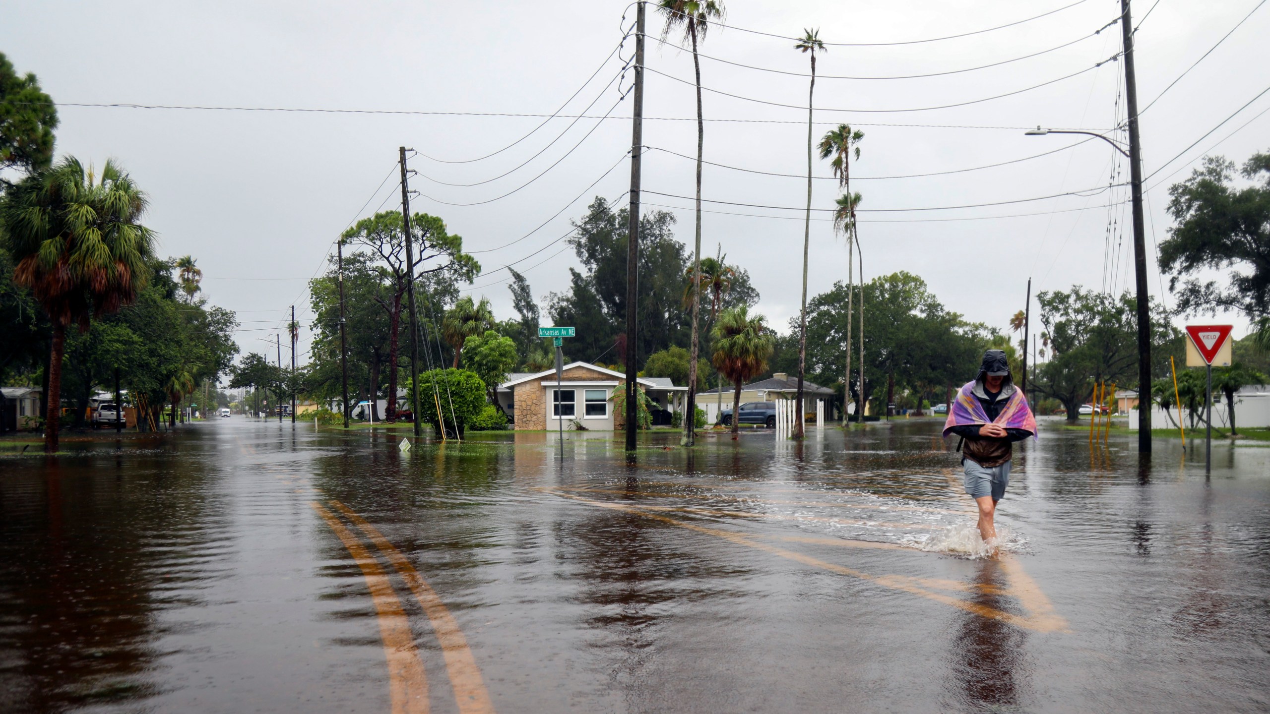 Carter Grooms, 25, of Tampa, wades through the streets in the Shore Acres neighborhood of St. Petersburg, Fla., Monday morning, Aug 5, 2024, as Hurricane Debby passed the Tampa Bay area offshore. (Dylan Townsend/Tampa Bay Times via AP)