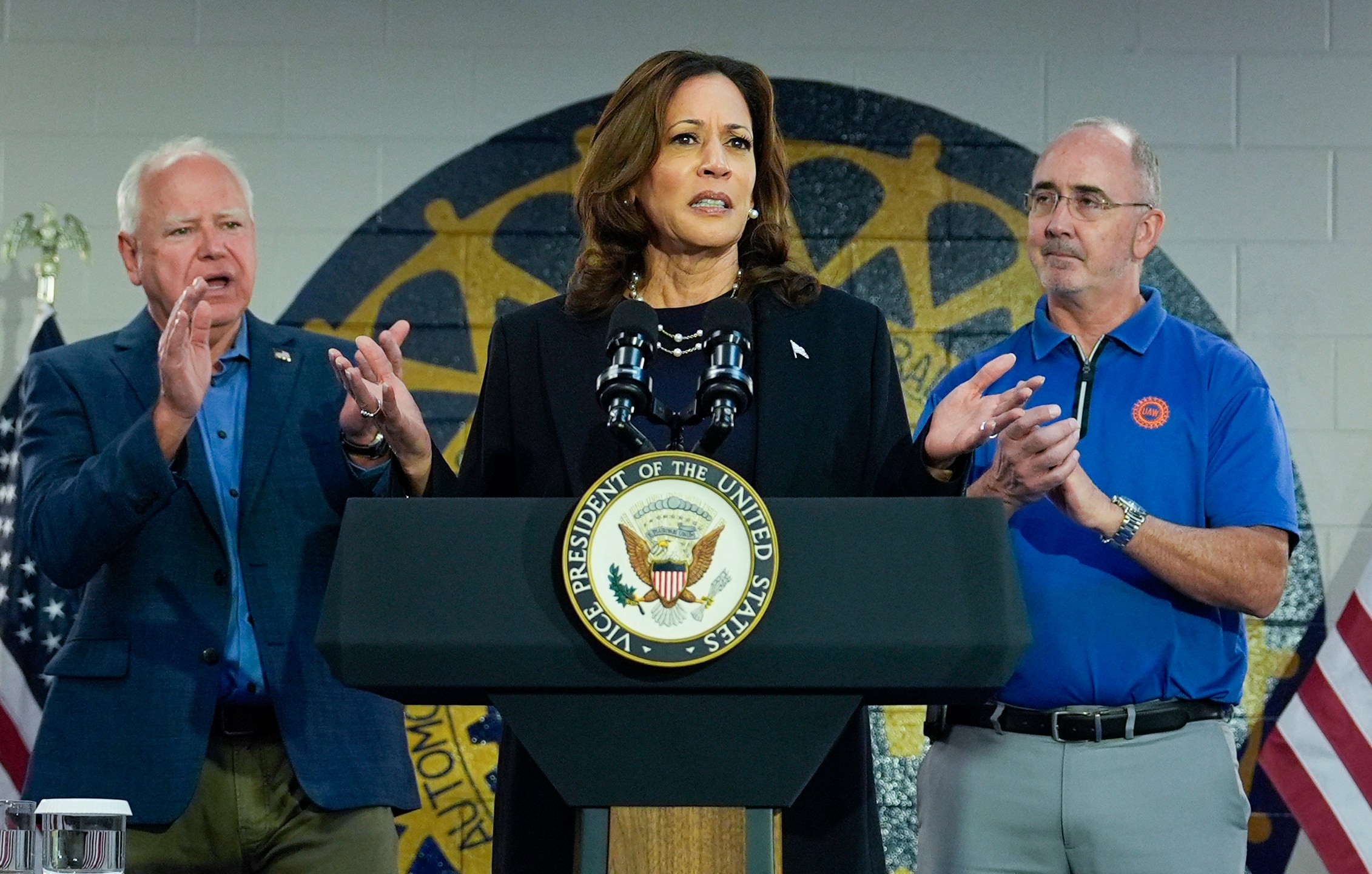 Democratic presidential nominee Vice President Kamala Harris, with Democratic vice presidential nominee Minnesota Gov. Tim Walz, left, and Shawn Fain, President of the UAW, right, speaks at a campaign rally at UAW Local 900, Thursday, August 8, 2024, in Wayne, Mich. (AP Photo/Julia Nikhinson)