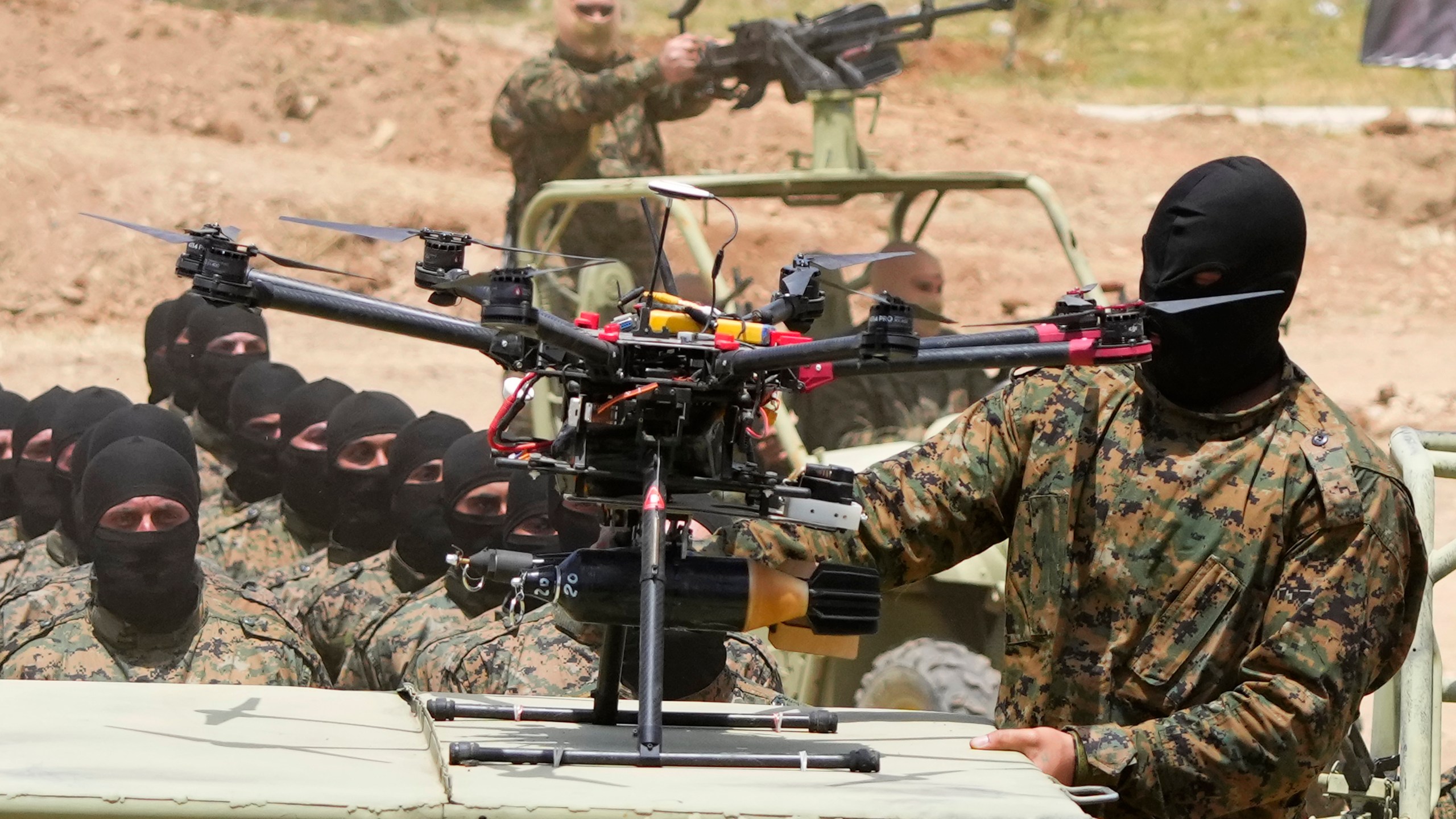 A Hezbollah fighter stands next to an armed drone during a training exercise in Aaramta village in the Jezzine District, southern Lebanon, on May 21, 2023. . (AP Photo/Hassan Ammar)