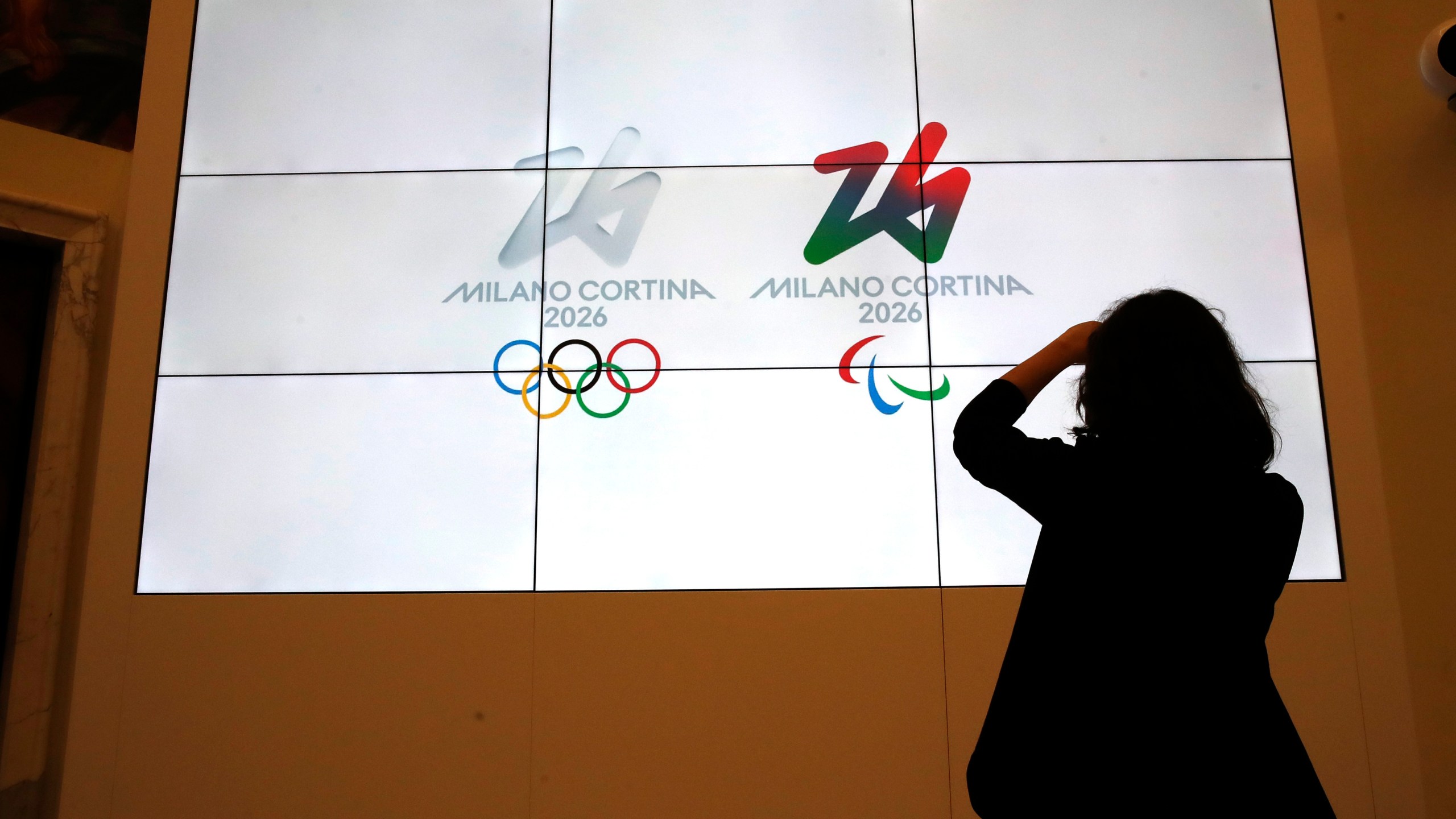 FILE - The logos of 2026 Milan-Cortina Olympics and Paralympics, right, are unveiled to the journalists at a press conference in Rome, Tuesday, March 30, 2021. (AP Photo/Alessandra Tarantino, File)