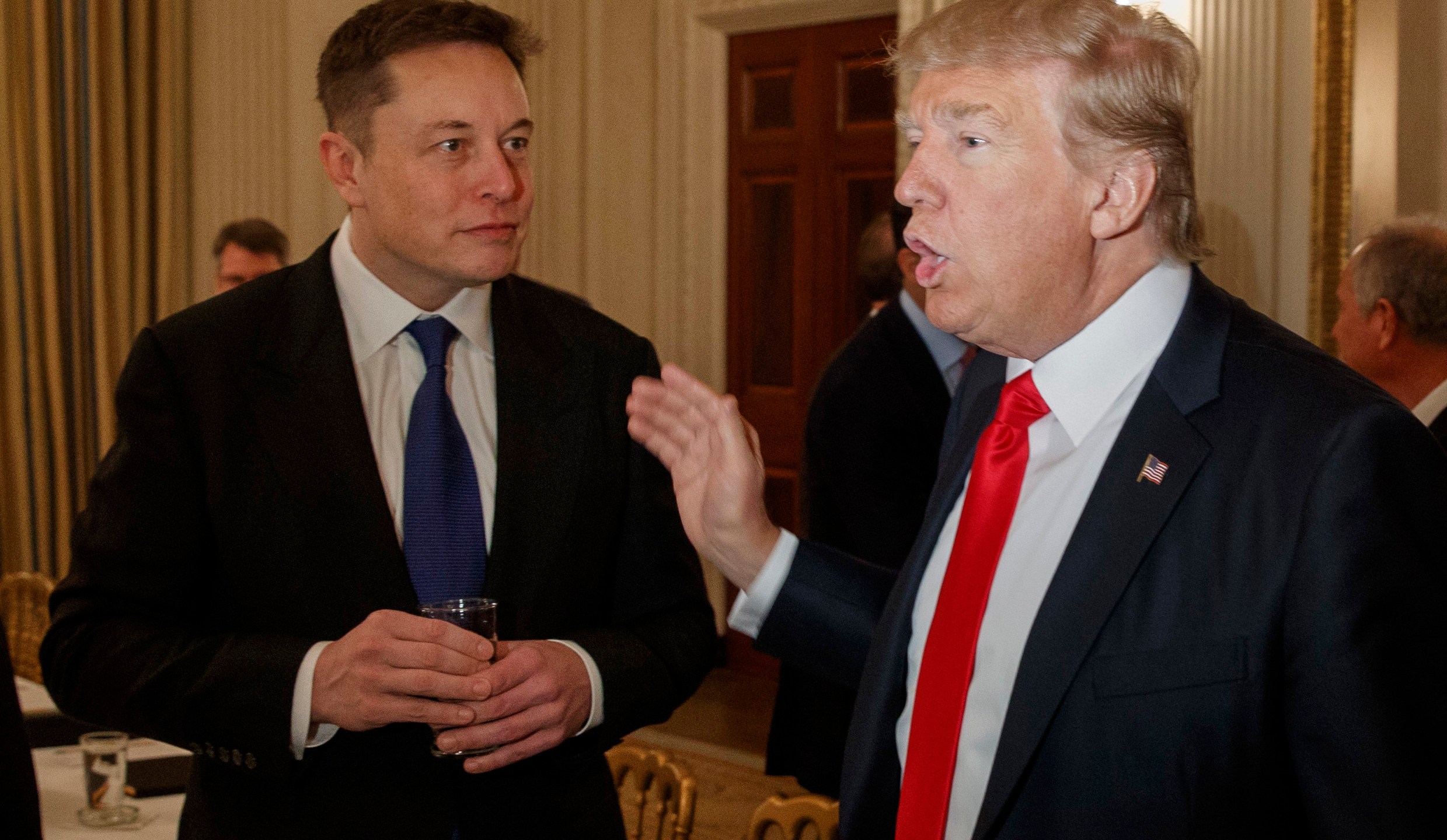 FILE - President Donald Trump, right, talks with Tesla and SpaceX CEO Elon Musk at the White House in Washington, Feb. 3, 2017. (AP Photo/Evan Vucci, File)