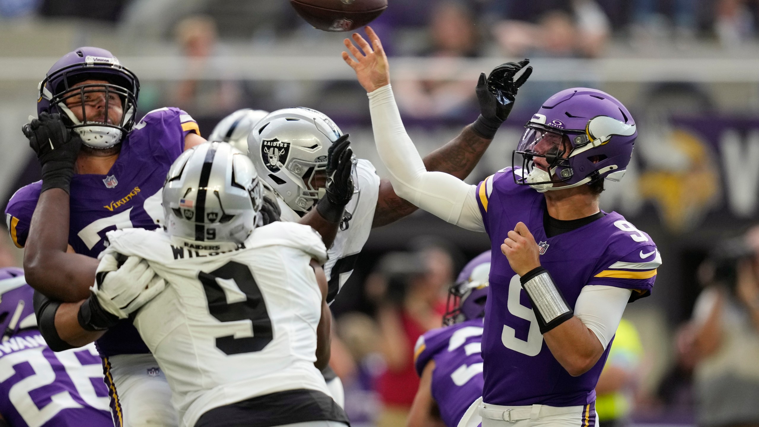 Minnesota Vikings quarterback J.J. McCarthy (9) throws against the Las Vegas Raiders under pressure during the first half of an NFL football game Saturday, Aug. 10, 2024, in Minneapolis. (AP Photo/Charlie Neibergall)