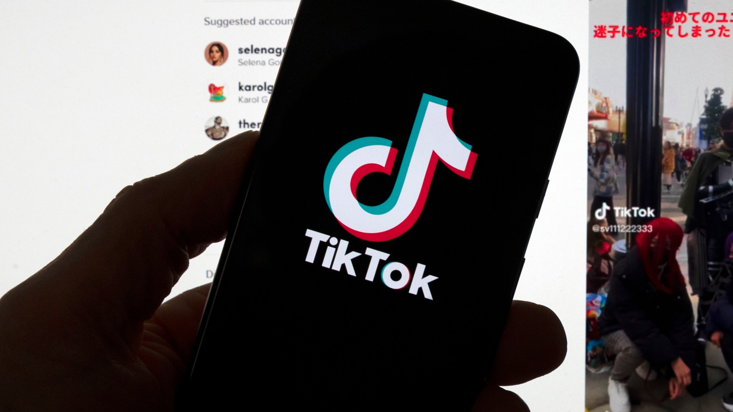 FILE - The TikTok logo is seen on a mobile phone in front of a computer screen which displays the TikTok home screen, March 18, 2023, in Boston. (AP Photo/Michael Dwyer, File)