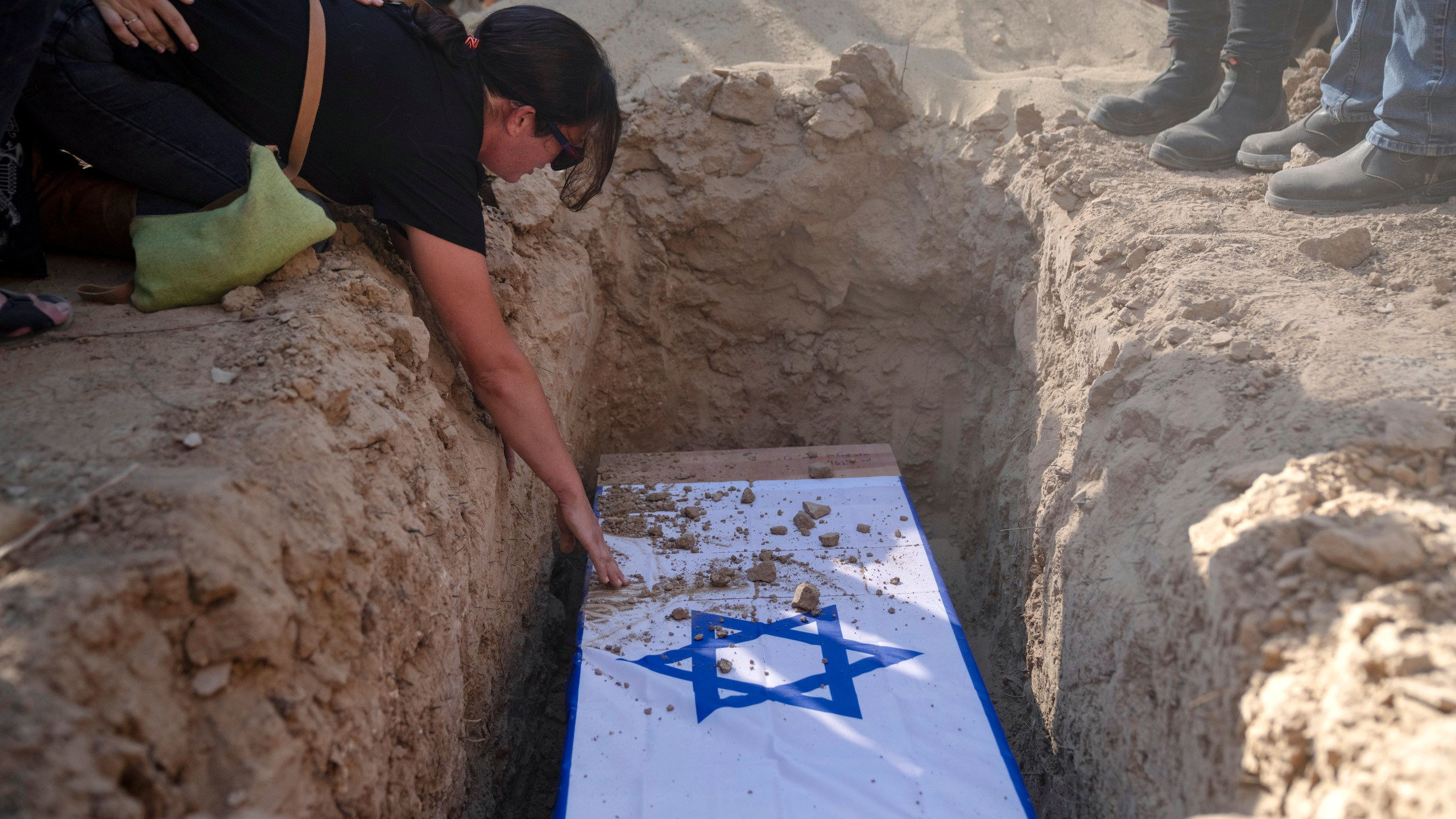 Rimon Buchshtab mourns during the funeral of her husband Yagev Buchshtab at a cemetery of the Kibbutz Nirim, southern Israel, Wednesday, Aug. 21, 2024. Buchshtab's body was one of six bodies of hostages, taken in Hamas' Oct. 7 attack, recovered by Israel's military during an operation in the Gaza Strip. (AP Photo/Leo Correa)