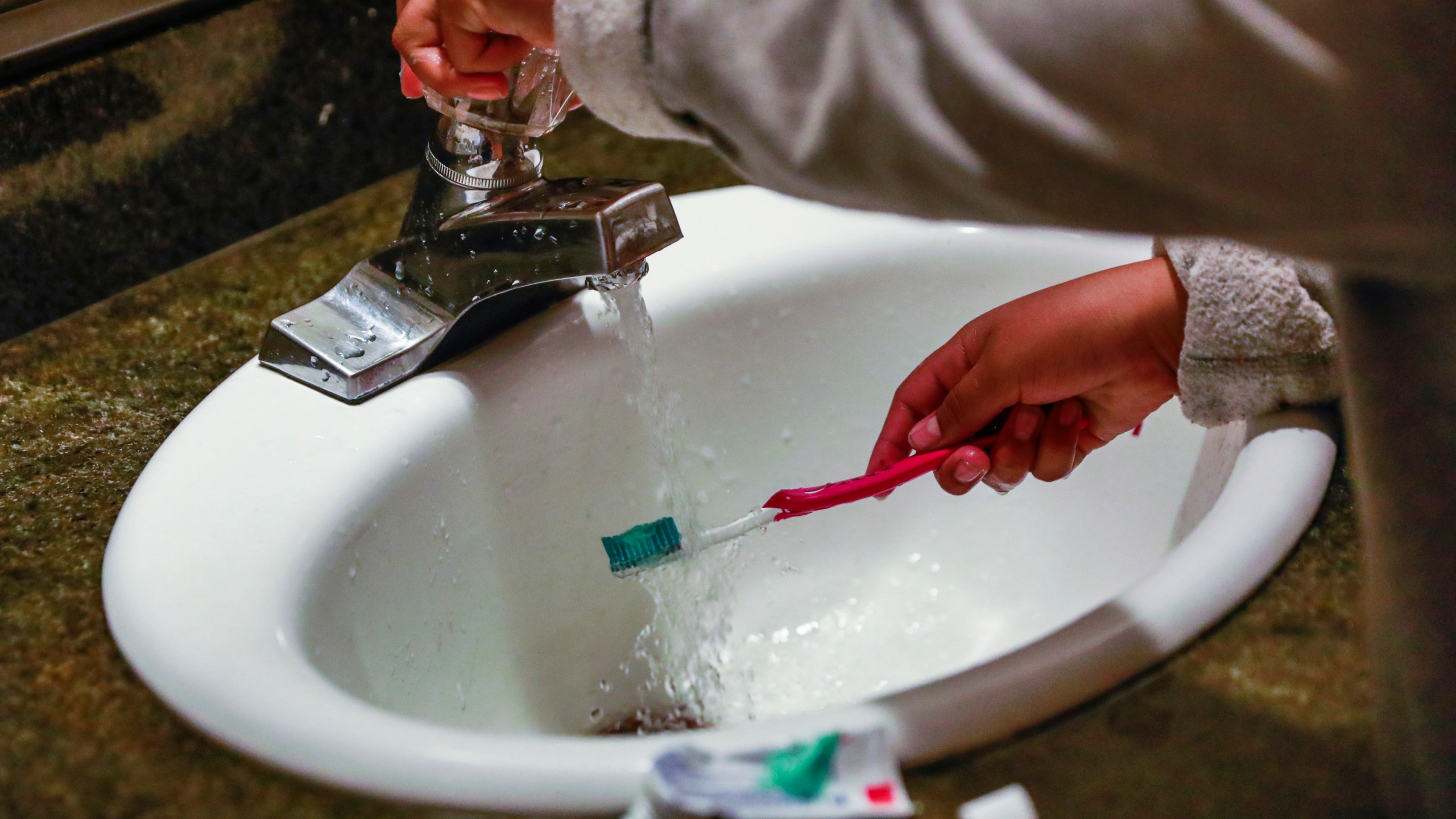 FILE - A child rinses a toothbrush in San Francisco on June 18, 2019. (Gabrielle Lurie/San Francisco Chronicle via AP, File)