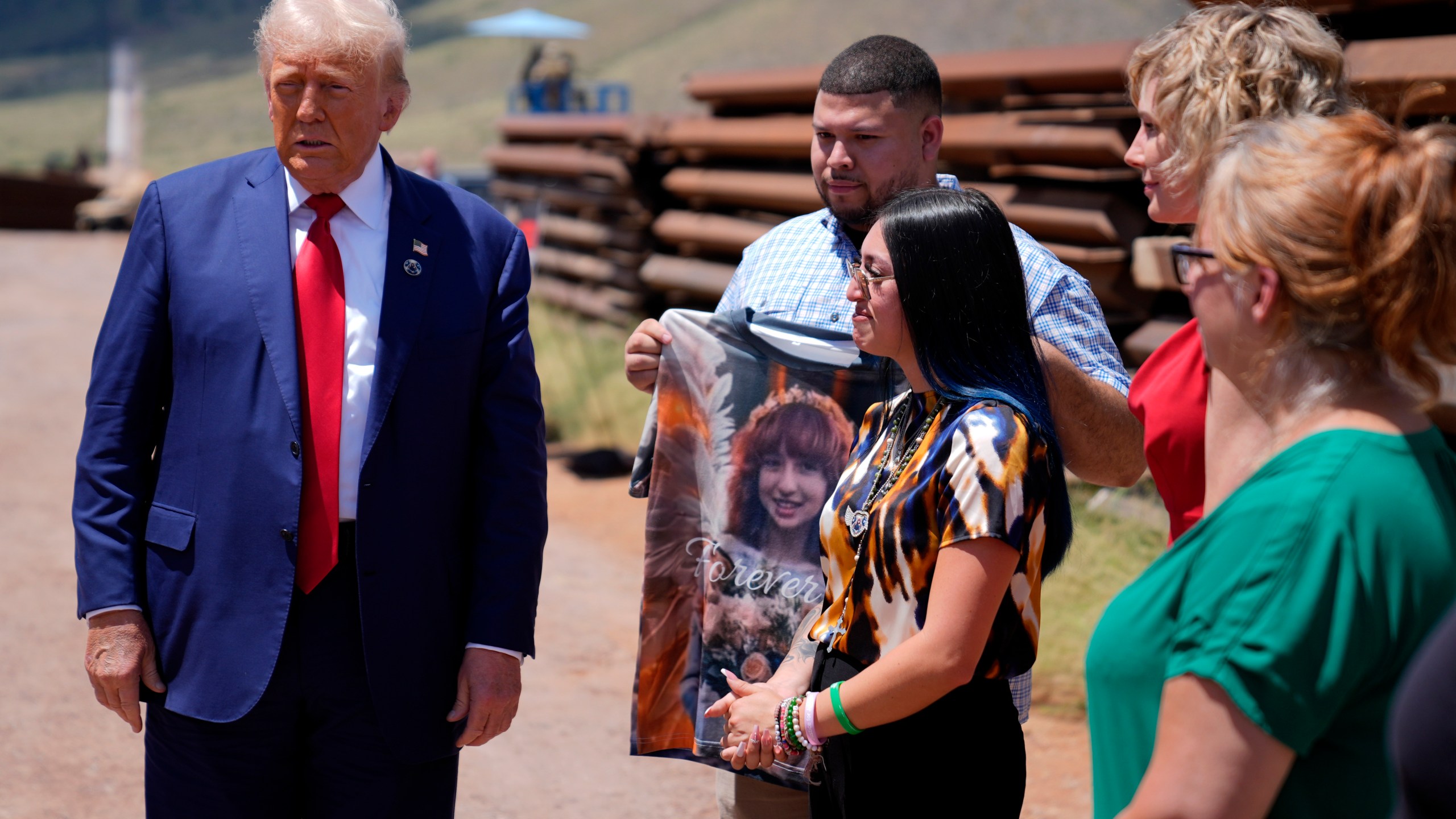 Republican presidential nominee former President Donald Trump speaks during a tour of the southern border with Mexico, Thursday, Aug. 22, 2024, in Sierra Vista, Ariz, as Alexis Nungaray, mother of Jocelyn, listens as Joamel Guevara holds a shirt with a photo of Jocelyn. (AP Photo/Evan Vucci)