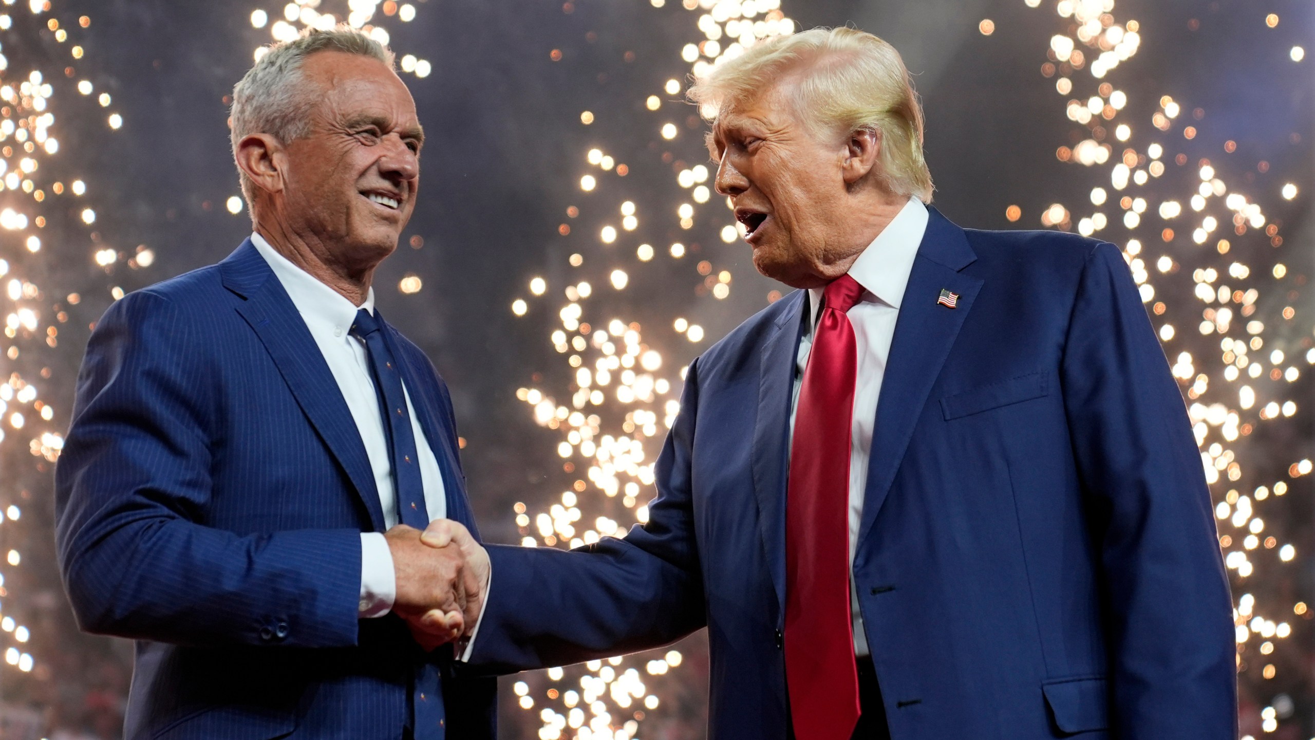 Republican presidential nominee former President Donald Trump shakes hands with Independent presidential candidate Robert F. Kennedy Jr. at a campaign rally at the Desert Diamond Arena, Friday, Aug. 23, 2024, in Glendale, Ariz. (AP Photo/Evan Vucci)