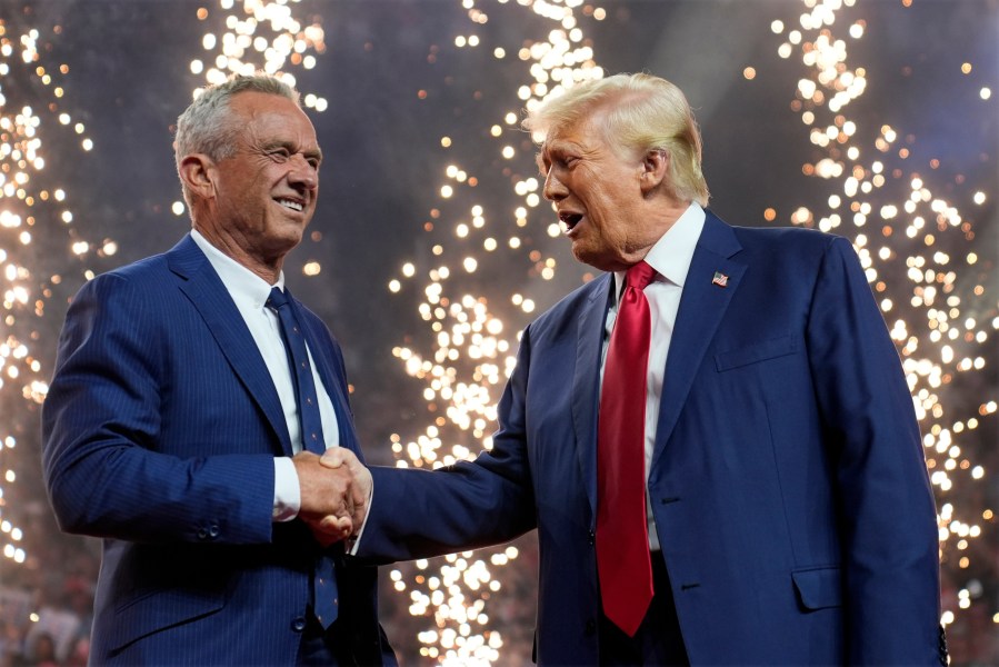 Republican presidential nominee former President Donald Trump shakes hands with Independent presidential candidate Robert F. Kennedy Jr. at a campaign rally at the Desert Diamond Arena, Friday, Aug. 23, 2024, in Glendale, Ariz. (AP Photo/Evan Vucci)