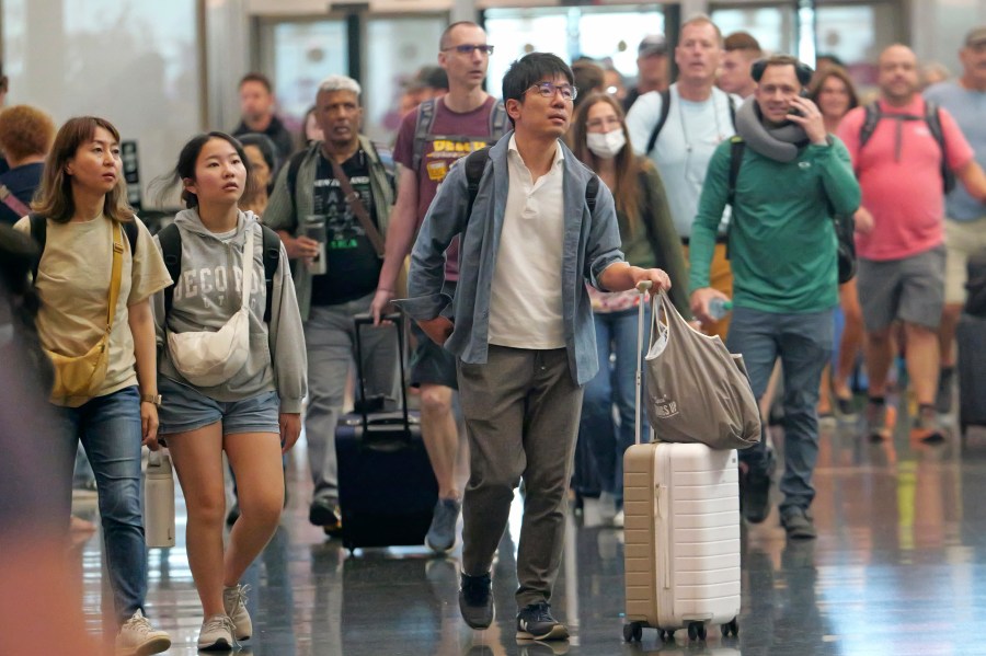 FILE - Travelers pass through Salt Lake City International Airport on July 3, 2024, in Salt Lake City. (AP Photo/Rick Bowmer, File)