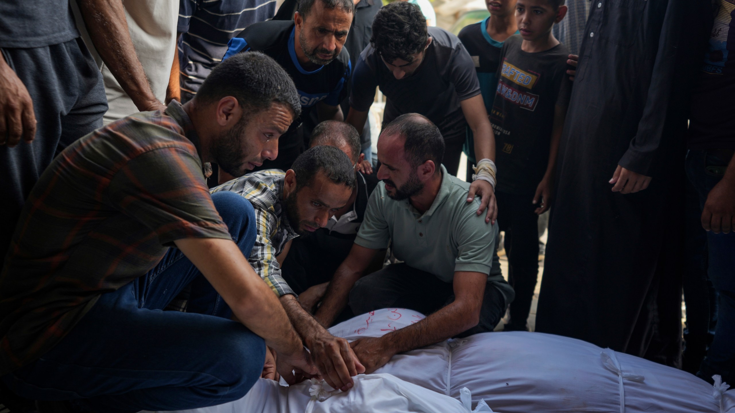 Palestinians mourn relatives killed in the Israeli bombardment of the Gaza Strip, at a hospital in Deir al-Balah, Tuesday, Aug. 27, 2024. (AP Photo/Abdel Kareem Hana)