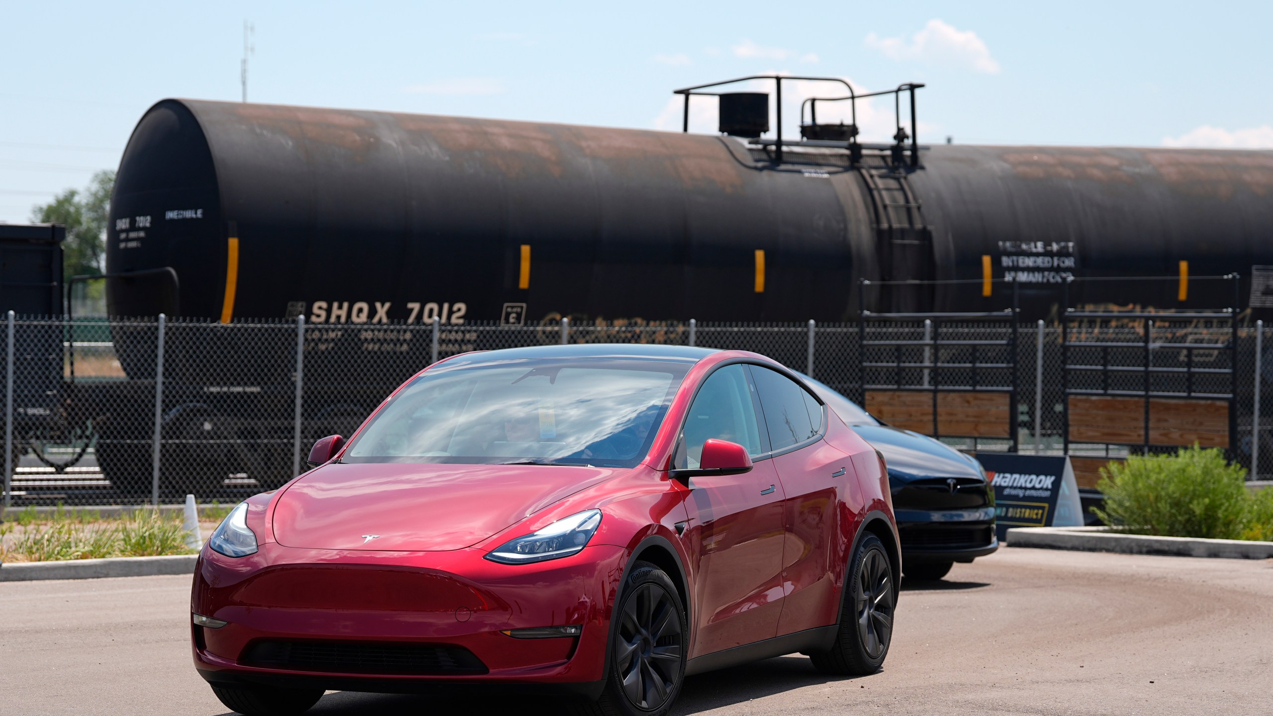 FILE - Drivers guide 2024 a Tesla Model 3 sedan and Model X utility vehicle, rear, along a test track at the Electrify Expo in The Yards on July 14, 2024, in north Denver. (AP Photo/David Zalubowski, File)