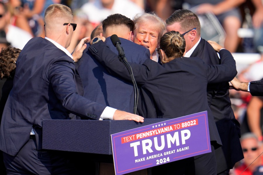 FILE - Republican presidential candidate former President Donald Trump is surrounded by Secret Service at a campaign event in Butler, Pa., July 13, 2024. A senior FBI official says the gunman in the assassination attempt of former President Donald Trump searched online for events of both Trump and President Joe Biden and saw the Pennsylvania campaign rally where he opened fire last month as a “target of opportunity." (AP Photo/Gene J. Puskar, File)