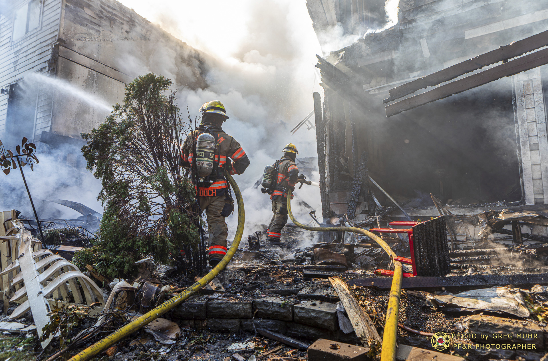 In this photo provided by Portland Fire & Rescue, firefighters use handlines to extinguish the fire adjacent to the primary structure involved after a small plane crashed Saturday, Aug. 31, 2024, in Fairview, Ore. (Greg Muhr/Portland Fire & Rescue via AP)