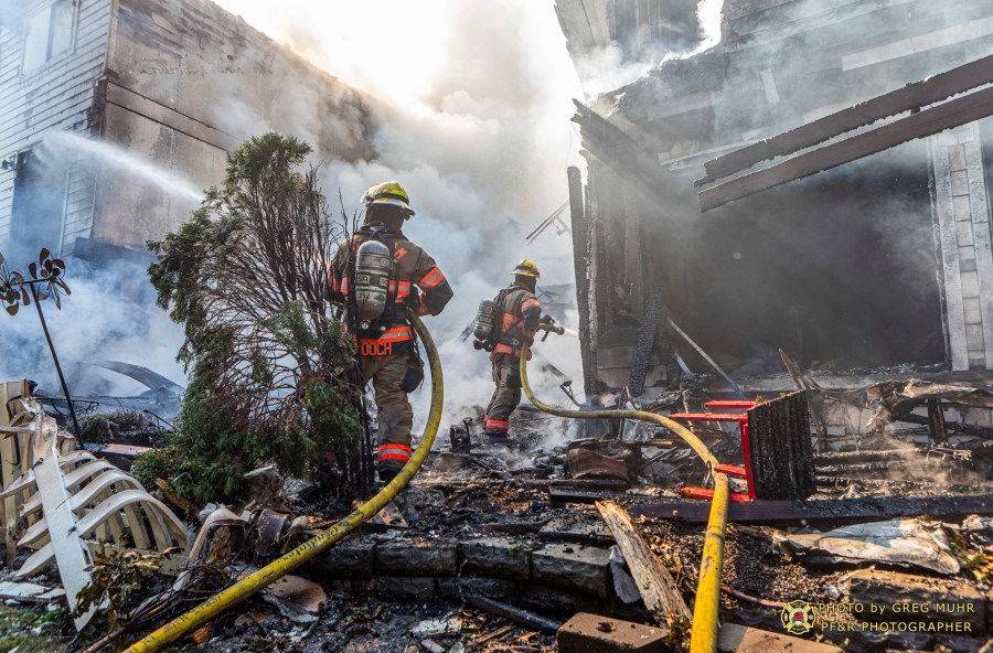 In this photo provided by Portland Fire & Rescue, firefighters use handlines to extinguish the fire adjacent to the primary structure involved after a small plane crashed Saturday, Aug. 31, 2024, in Fairview, Ore. (Greg Muhr/Portland Fire & Rescue via AP)