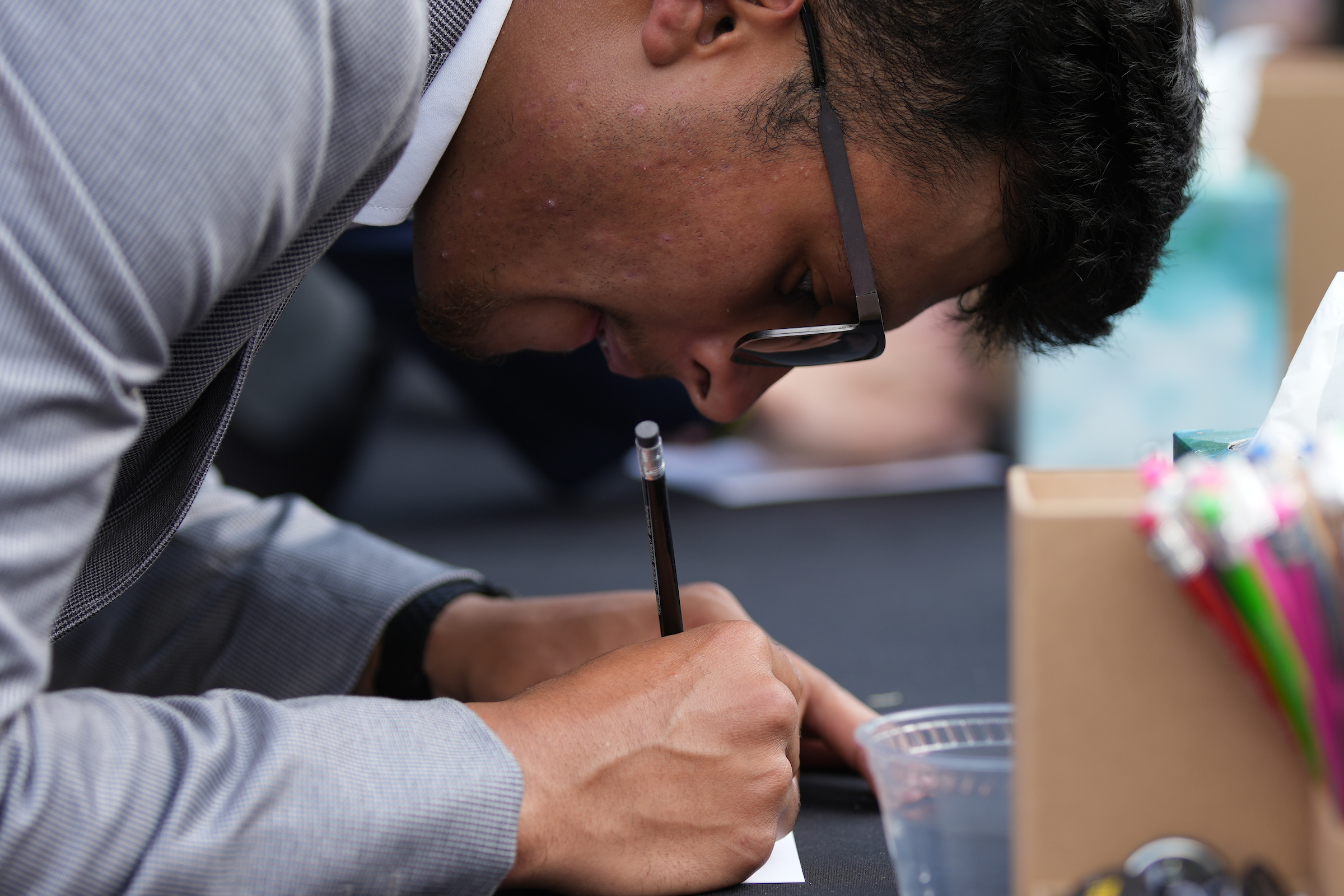 University of Idaho community members write hand written notes at the Vandal Healing Garden and Memorial dedication ceremony on Aug. 21, 2024.