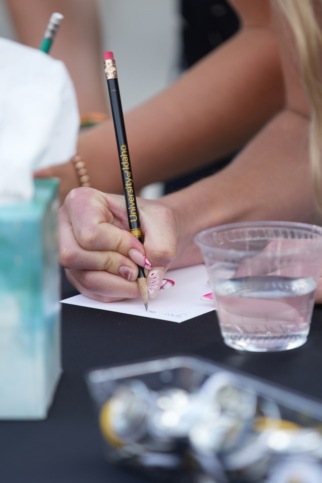 University of Idaho community members write hand written notes at the Vandal Healing Garden and Memorial dedication ceremony on Aug. 21, 2024.