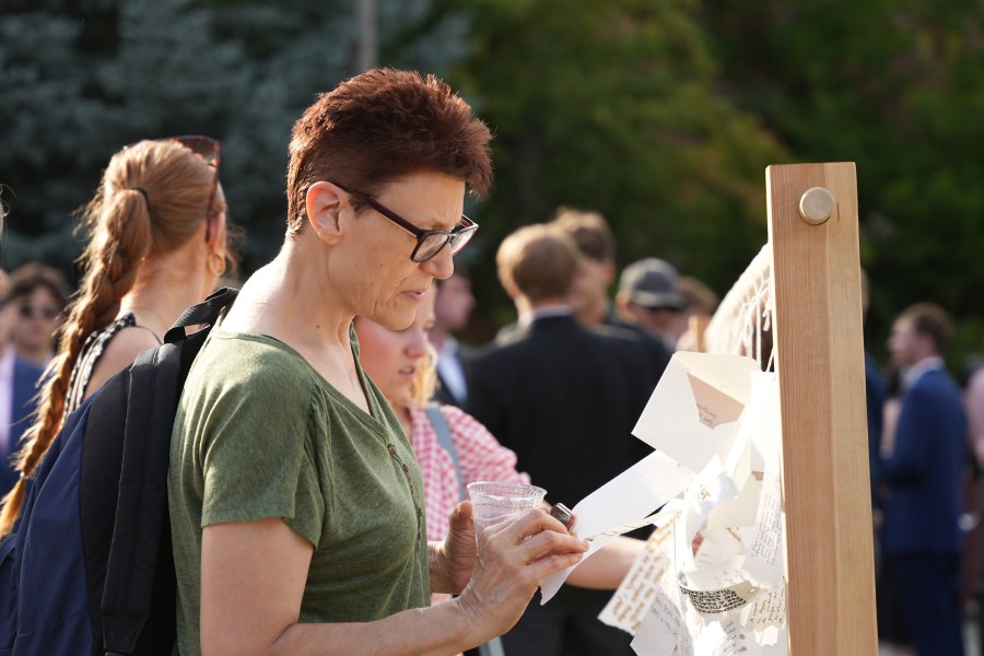 University of Idaho community members write hand written notes at the Vandal Healing Garden and Memorial dedication ceremony on Aug. 21, 2024.