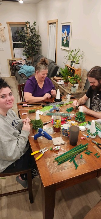 A man and two women crafting.