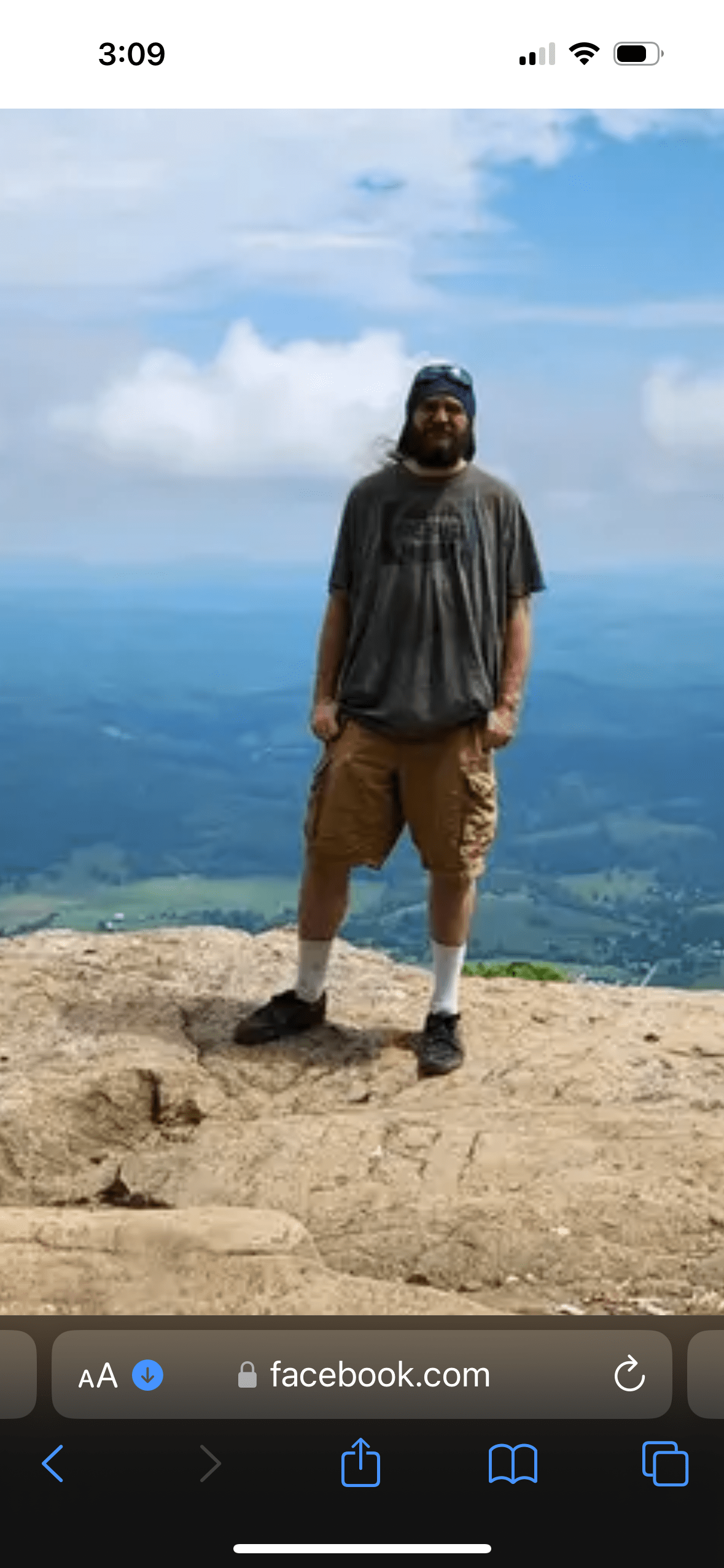 A young bearded man on a cliff.