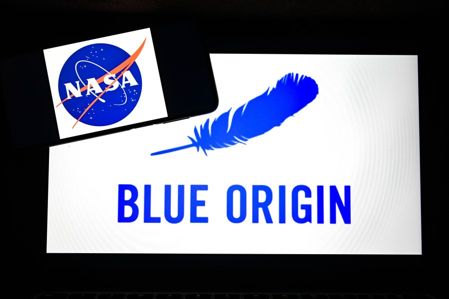 The logo of NASA is displayed on mobile phone screen in front of Blue Origin icon