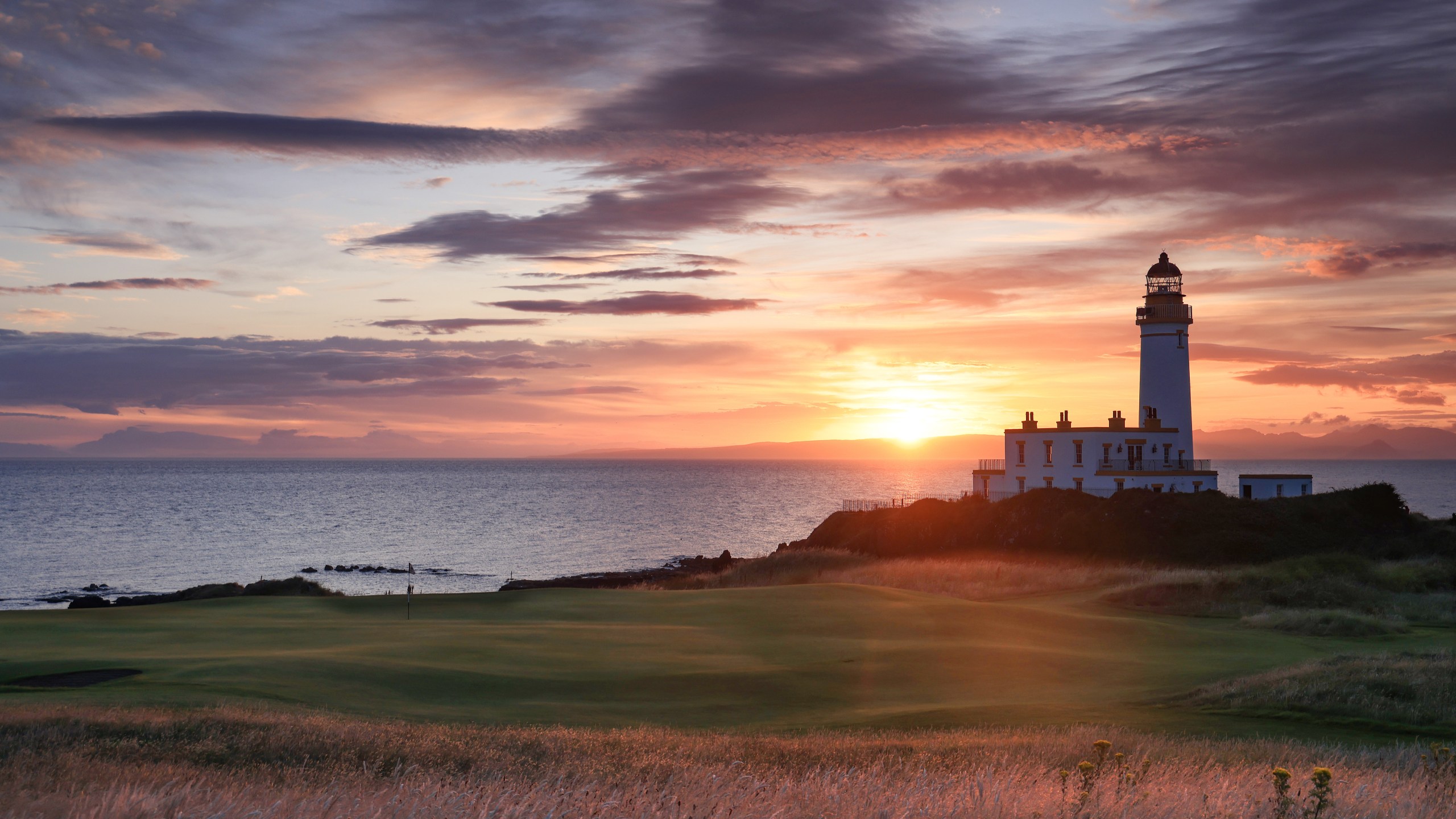 A view of the green on the par 3, ninth hole beside The Turnberry Lighthouse as sunset on the Ailsa golf course at Trump Turnberry resort in Scotland.