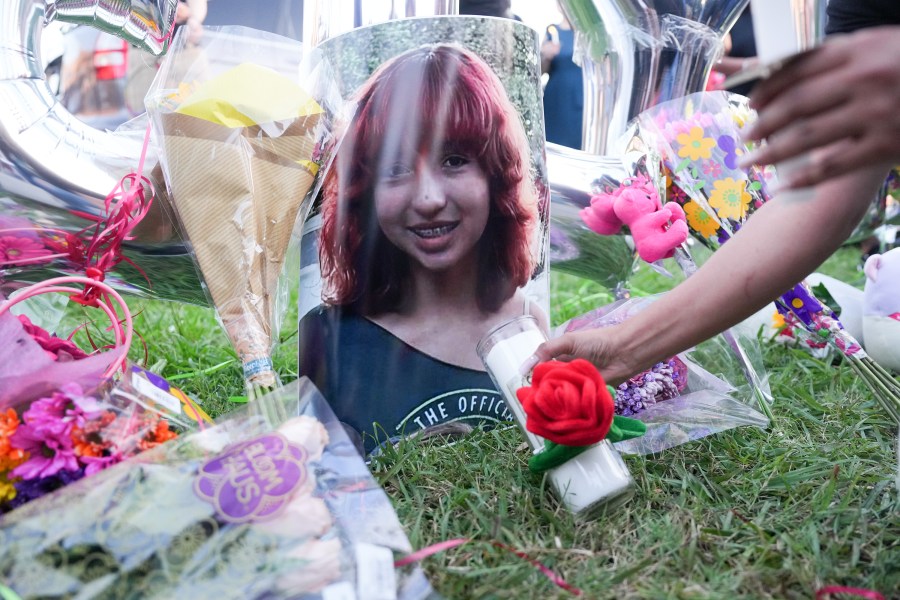 An attendee places a candle near a photo of 12-year-old Jocelyn Nungaray in Houston.