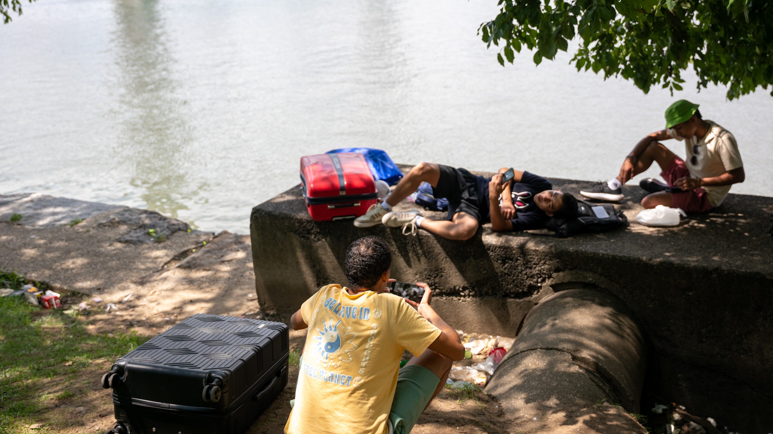 Young men from Venezuela, who are living in a tent, sit with their luggage after reaching their time limits at city-run shelters for migrants and their families on August 12, 2024, in New York City.