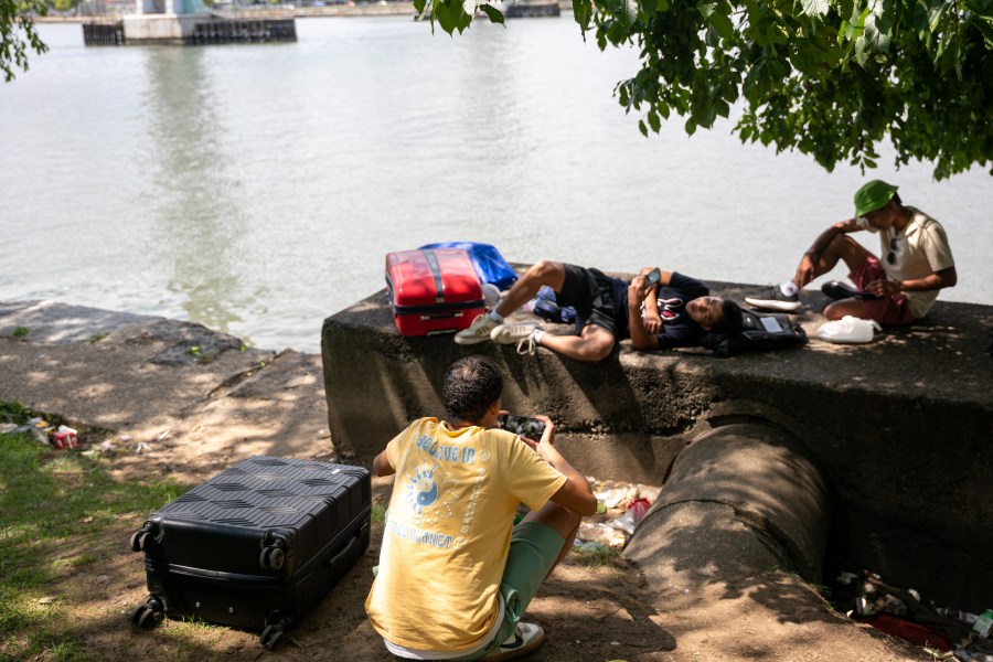 Young men from Venezuela, who are living in a tent, sit with their luggage after reaching their time limits at city-run shelters for migrants and their families on August 12, 2024, in New York City.