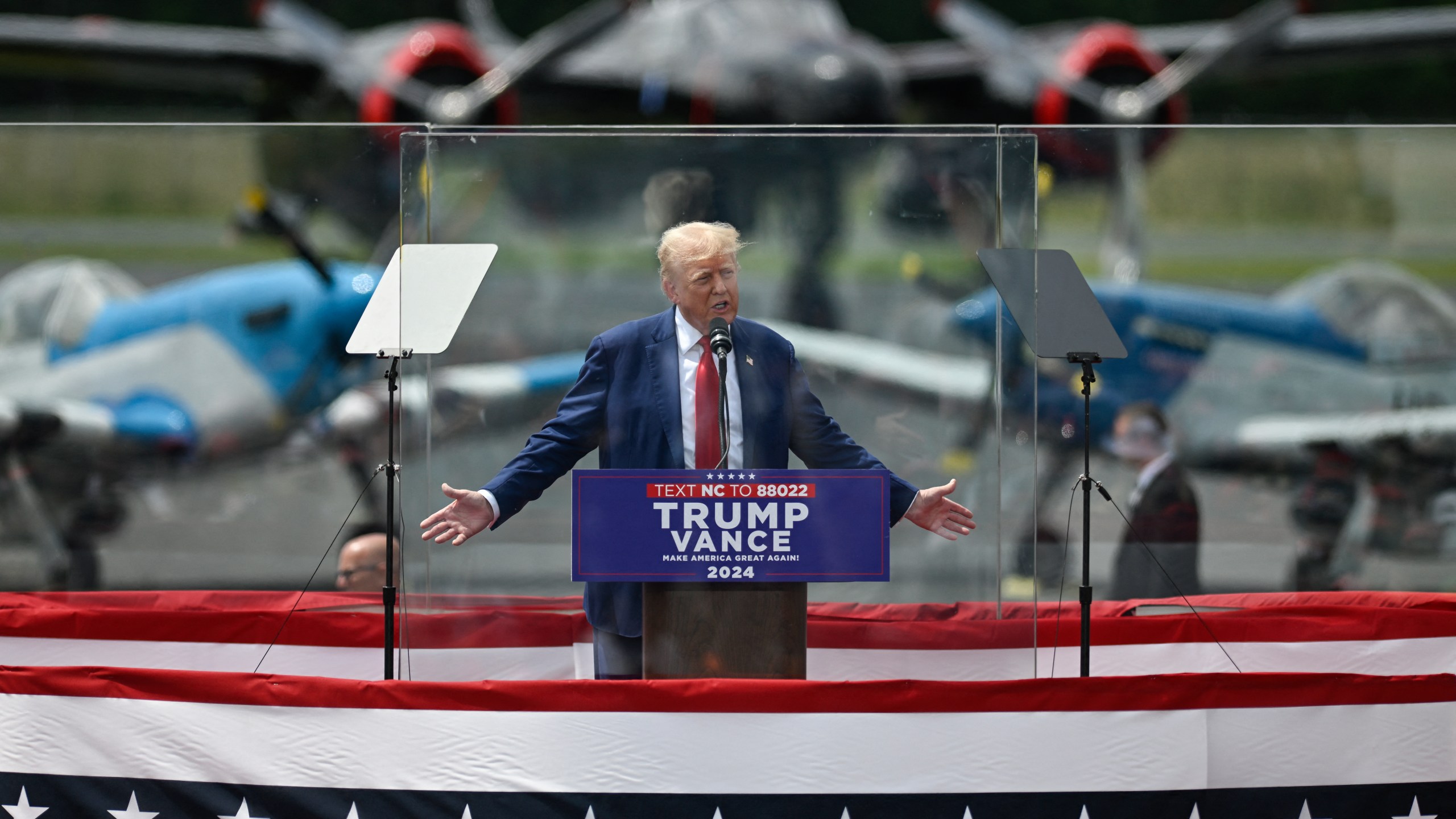 Donald Trump speaks behind bulletproof glass during a campaign rally in North Carolina on Aug. 21, 2024.