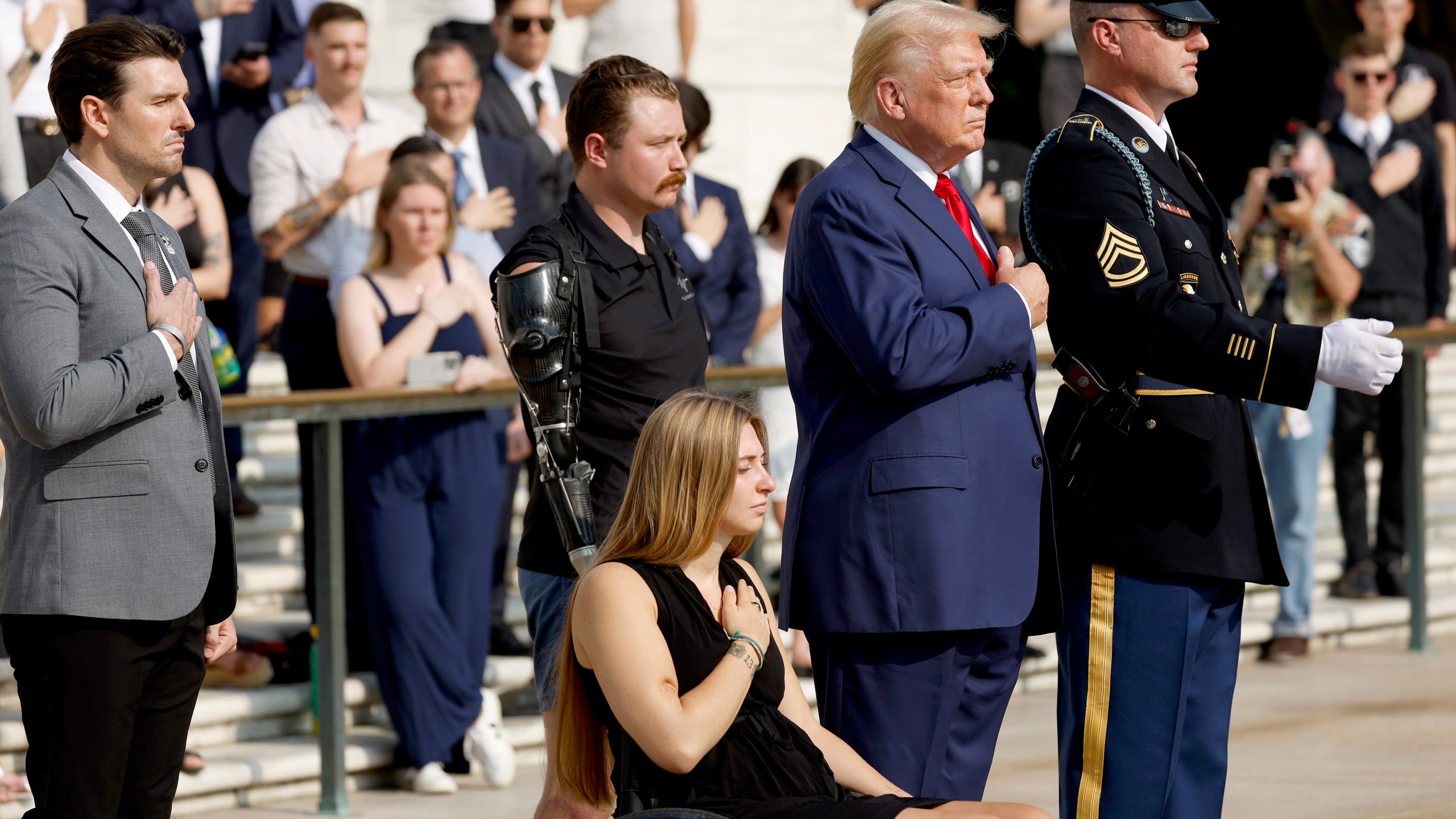 Former President Donald Trump holds his hand over his heart during a wreath-laying ceremony