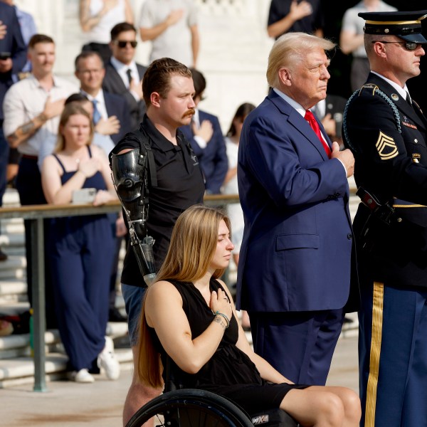 Former President Donald Trump holds his hand over his heart during a wreath-laying ceremony