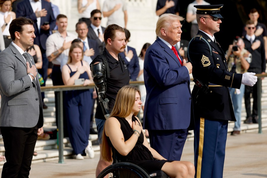 Former President Donald Trump holds his hand over his heart during a wreath-laying ceremony