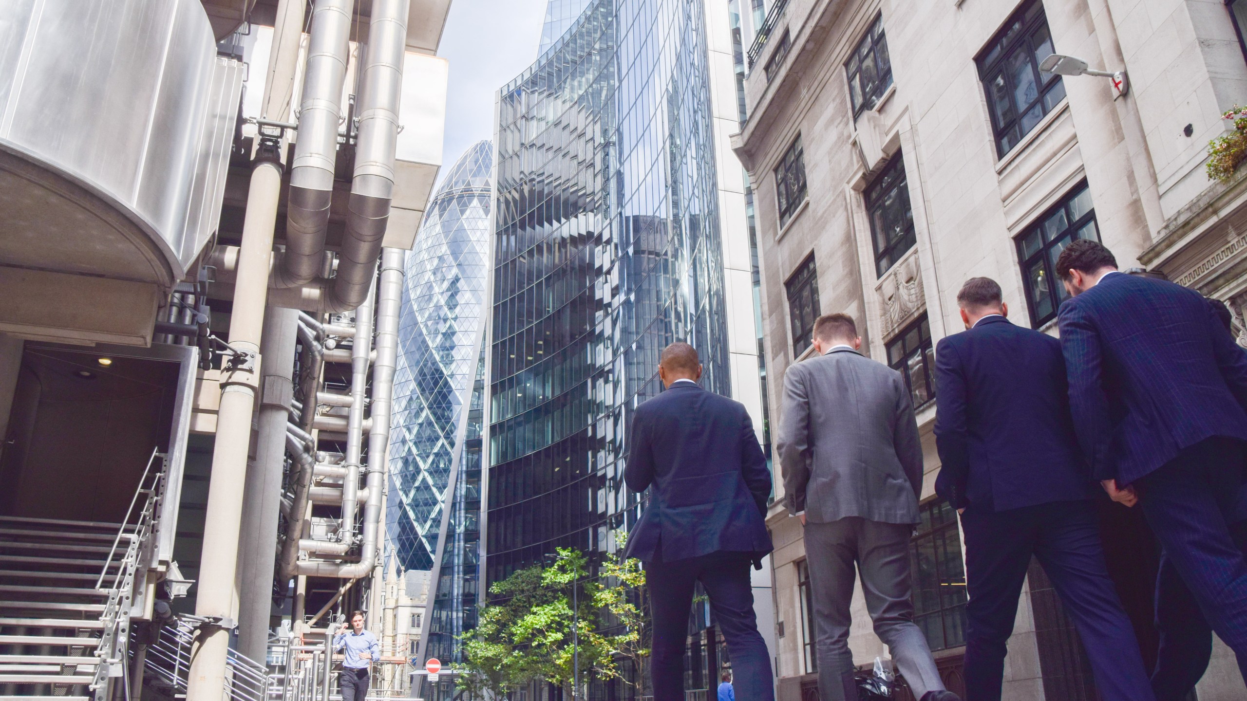 Workers walk outside office buildings in the City of London