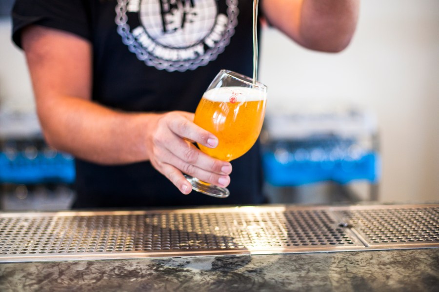 A bartender at New Belgium Brewing Company, pours a beer for a customer at the brewery's liquid center in Asheville, North Carolina.