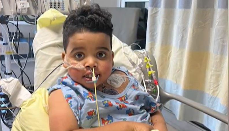 John-Henry Lee, 6, sits in a hospital bed