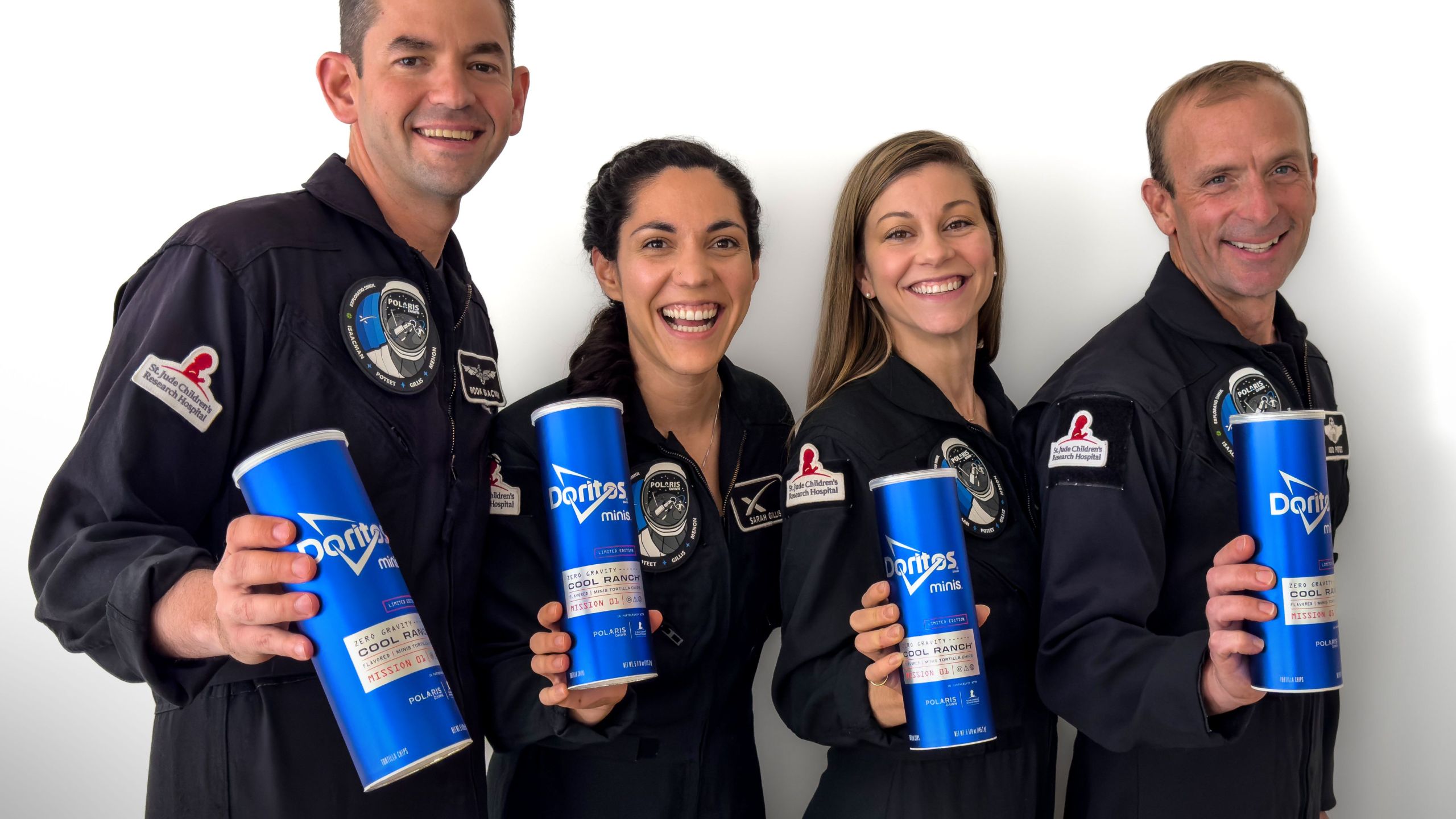 The astronauts who will be the first to eat Doritos in space holding Doritos