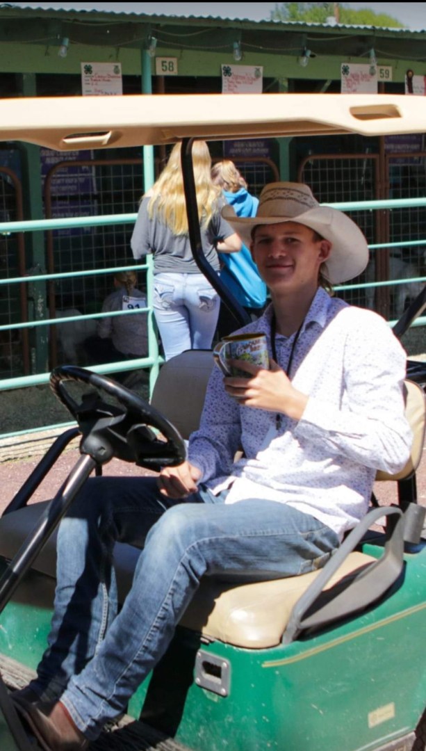 Jarrett Brooks in a cowboy hat, riding in a golf cart.