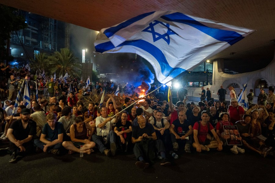 People block a road as they protest, calling for a deal for the immediate release of hostages held in the Gaza Strip by Hamas, in Tel Aviv, Israel, Sunday, Sept. 1, 2024. (AP Photo/Ohad Zwigenberg)