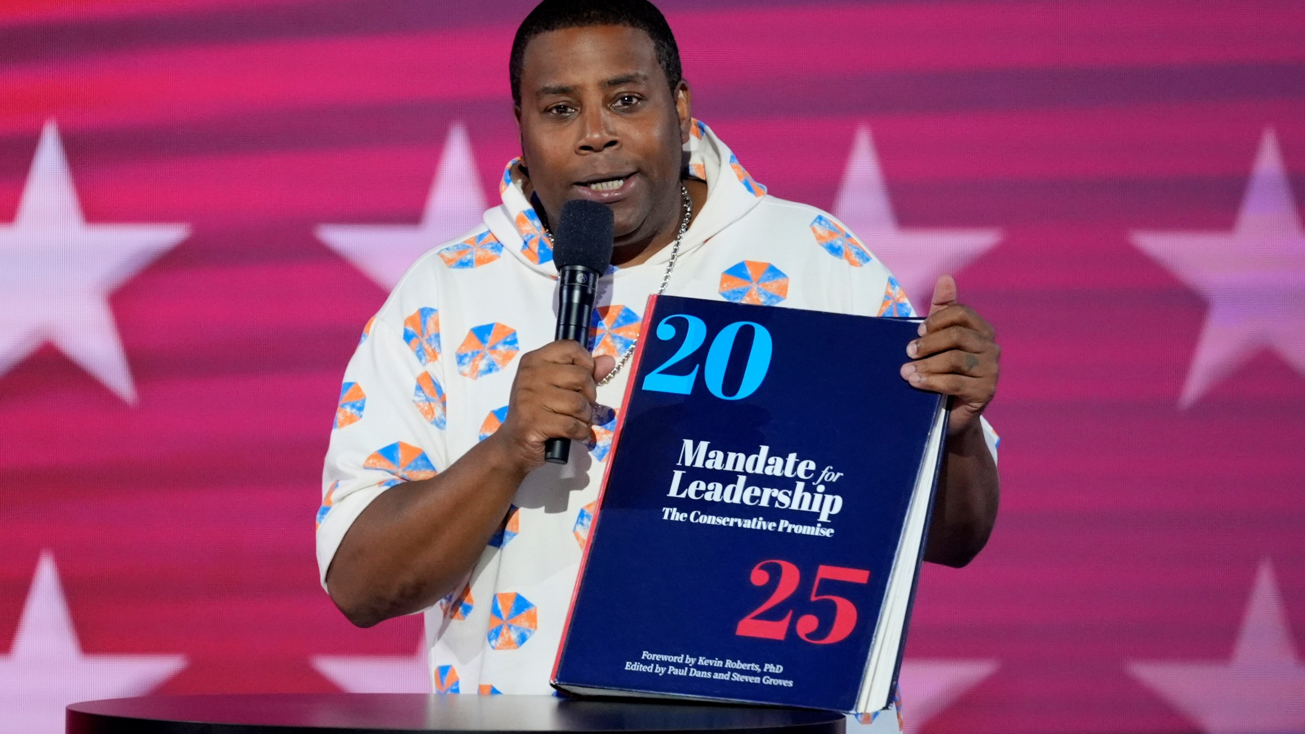 Kenan Thompson speaks as he carries a copy of Project 2025 on stage during the Democratic National Convention Wednesday, Aug. 21, 2024, in Chicago. (AP Photo/J. Scott Applewhite)