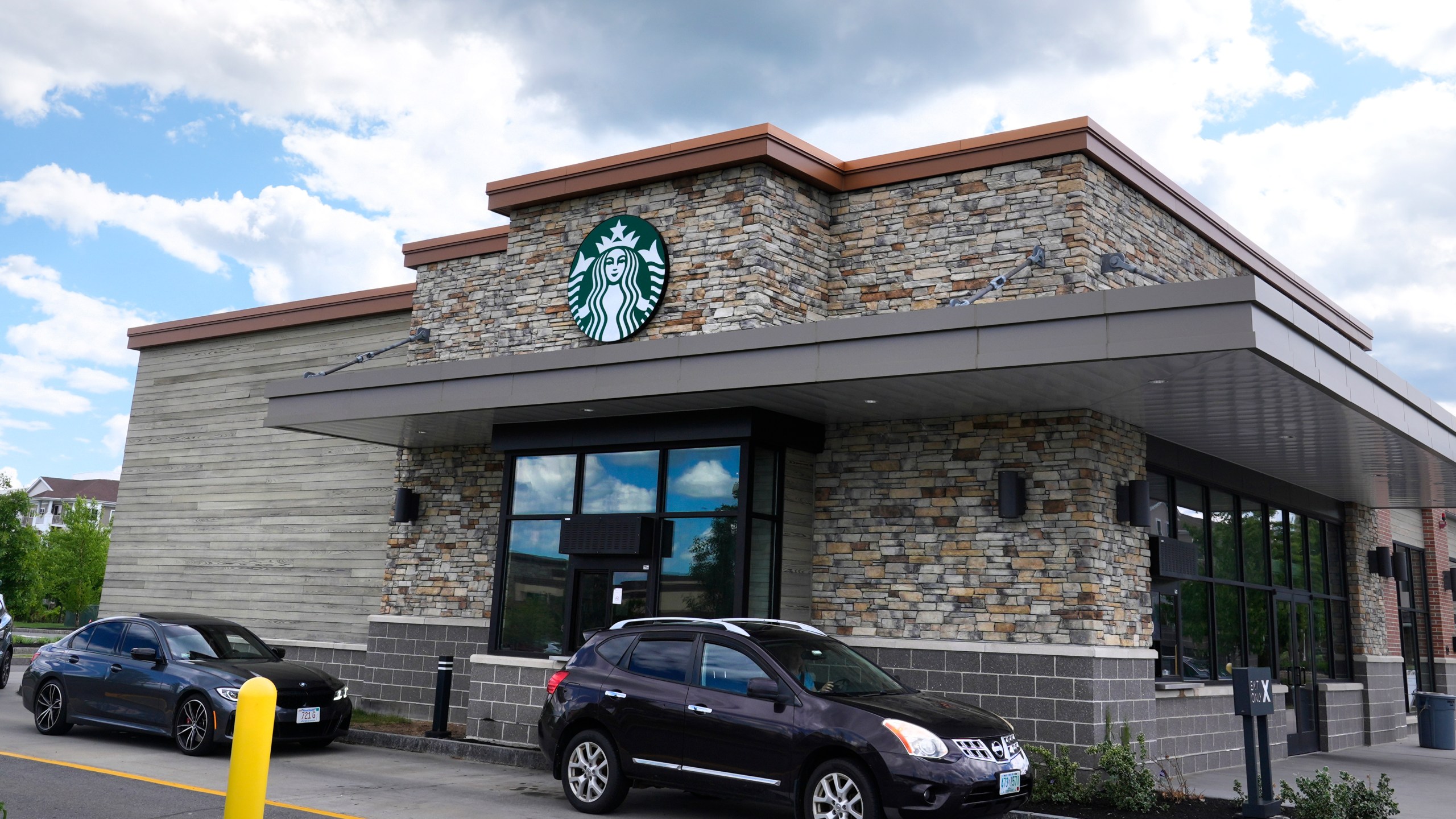 FILE - Cars drive through the pick-up window at a Starbucks store on May 29, 2024, in Salem, N.H. (AP Photo/Charles Krupa, FILE)