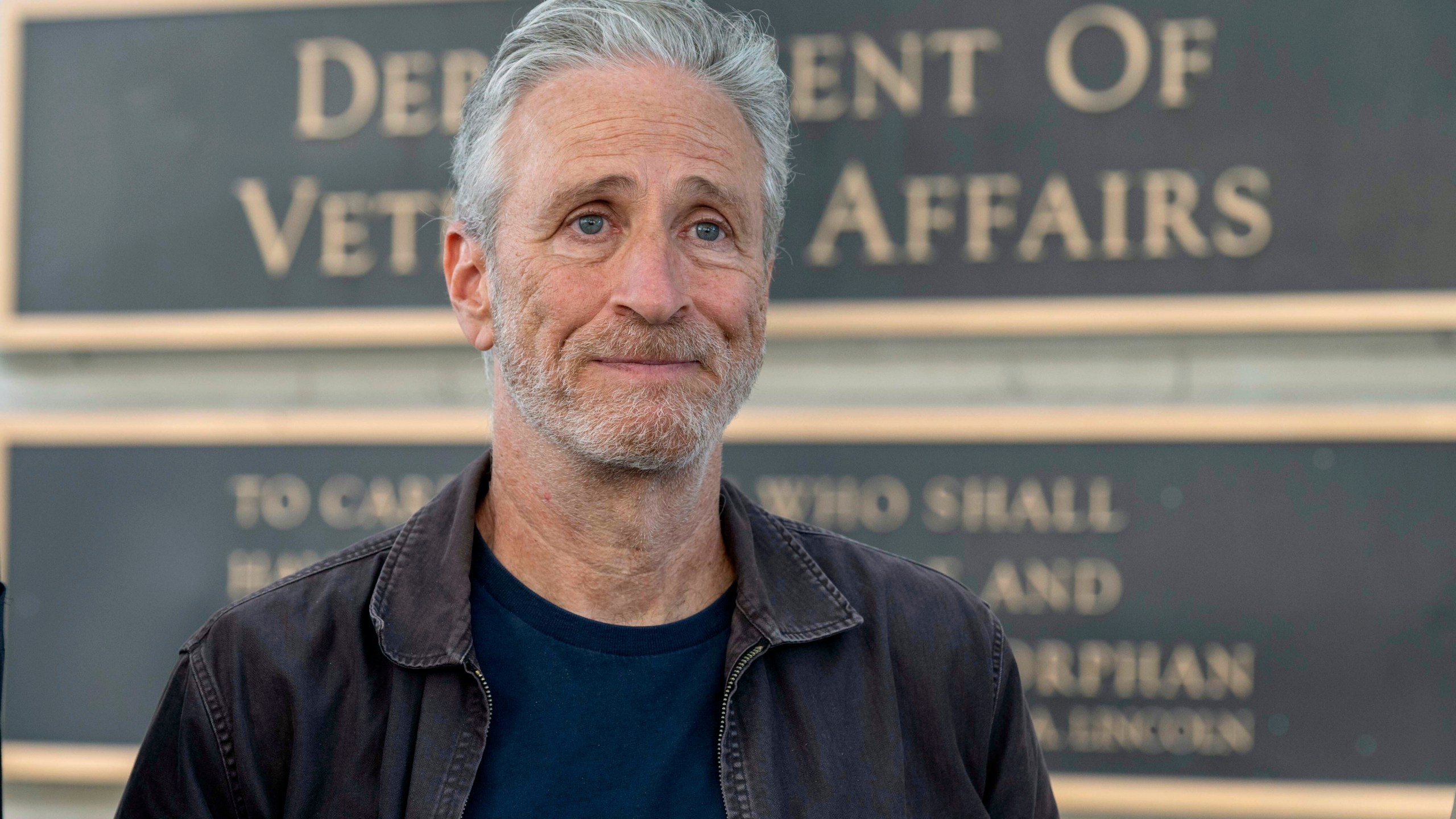 FILE - Jon Stewart takes part in an interview outside the Department of Veterans Affairs, July 26, 2024 in Washington. (AP Photo/Kevin Wolf, File)