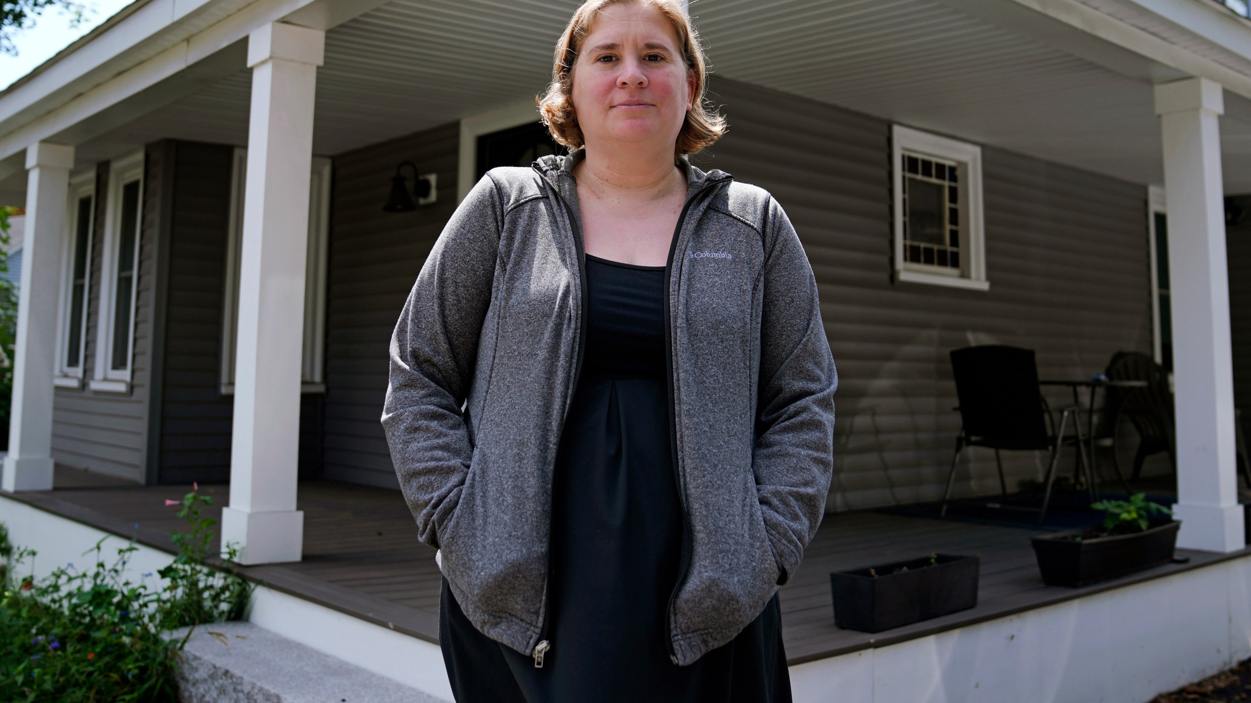 Rebecca Wood stands for a portrait outside her home, Friday, Aug. 30, 2024, in Maynard, Mass. Wood noticed a "program fee" required each time she loaded money onto her daughter's school lunch account. (AP Photo/Charles Krupa)