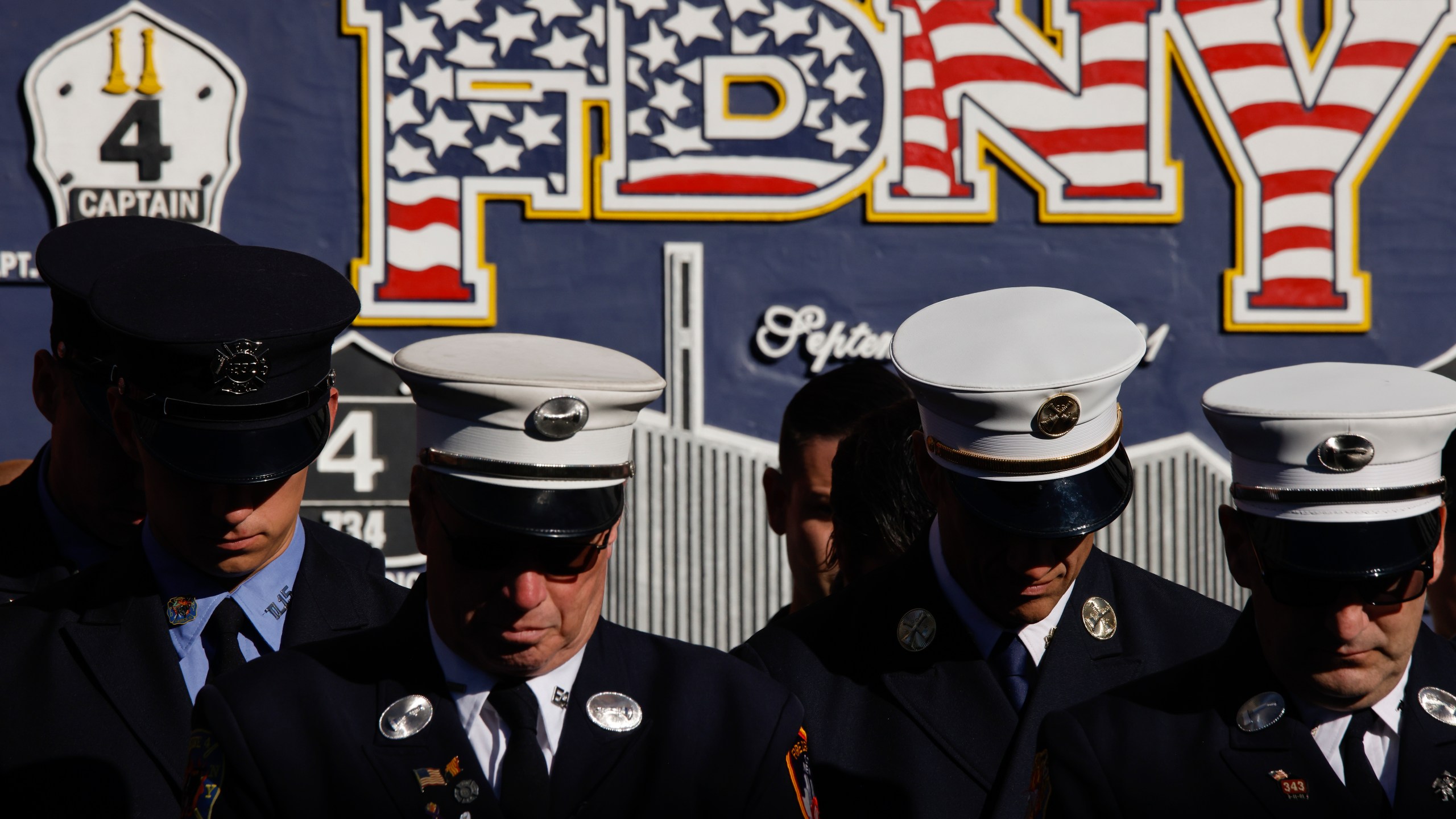 New York City firefighters bow their heads during a moment of silence outside Engine 4 Ladder 15 on the 23rd anniversary of the Sept. 11, 2001 attacks, Wednesday, Sept. 11, 2024, in New York. (AP Photo/Stefan Jeremiah)